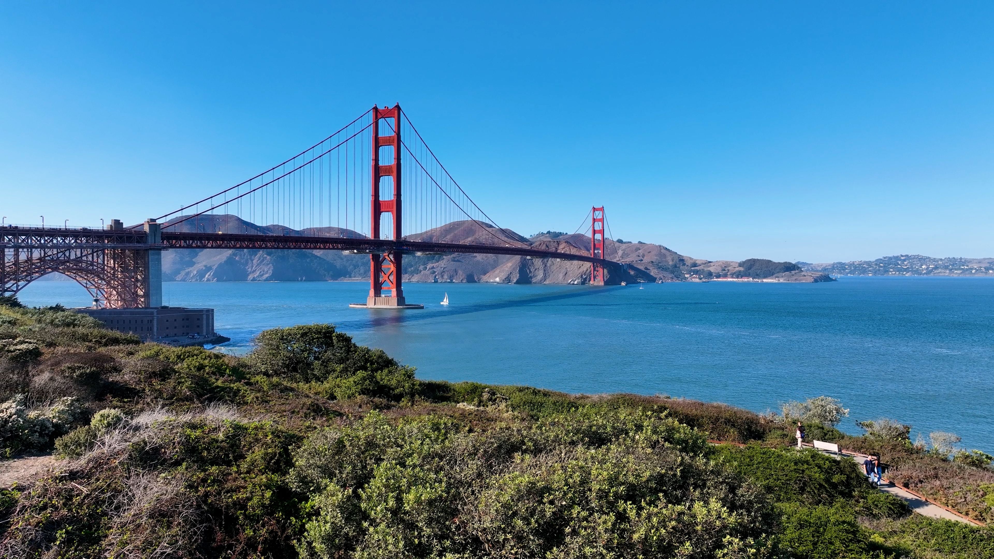 Die Golden Gate Bridge in San Francisco mit blauem Himmel und Meer im Vordergrund.