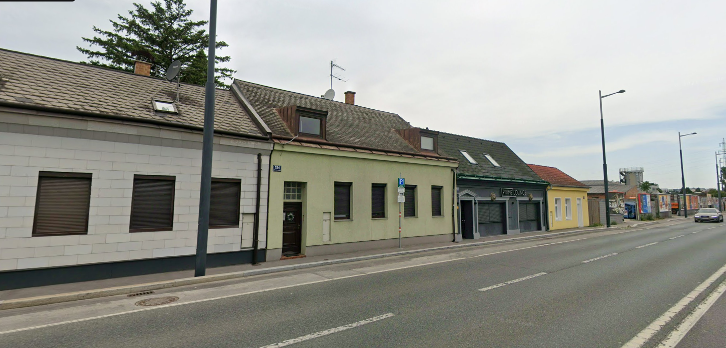 Straßenansicht mit mehreren Wohngebäuden und einem Lokal namens Prime Lounge.