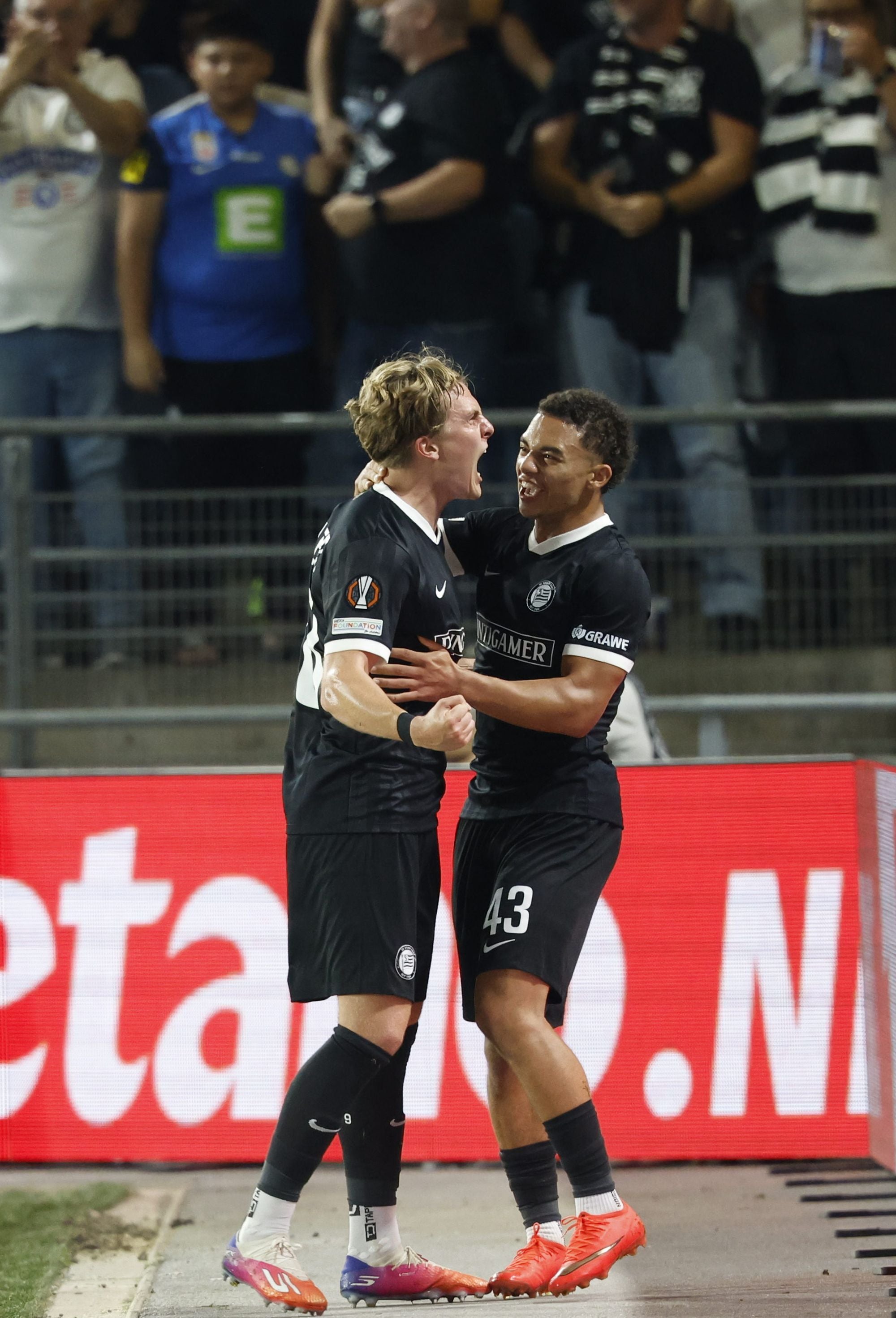 Zwei Spieler von Sturm Graz jubeln während eines Fußballspiels im Stadion.