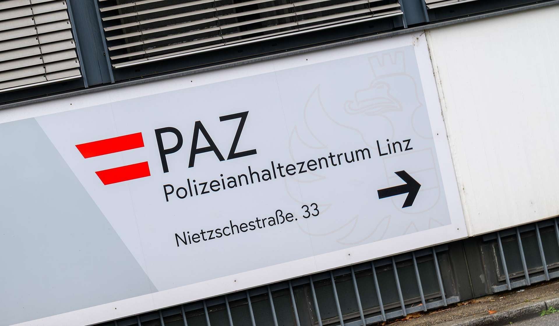 Schild mit Aufschrift "PAZ Polizeianhaltezentrum Linz" und Pfeil nach rechts.