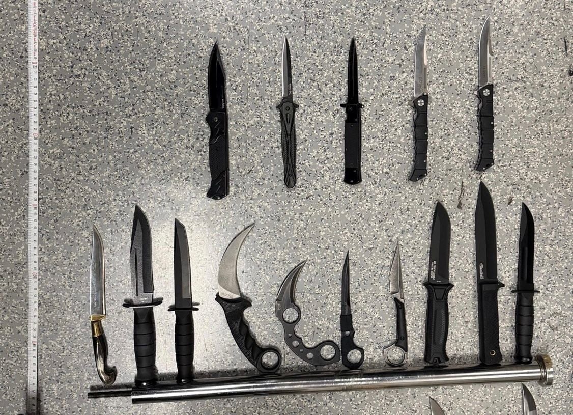Verschiedene große und kleine Messer sind auf einer grauen Fläche ausgelegt.