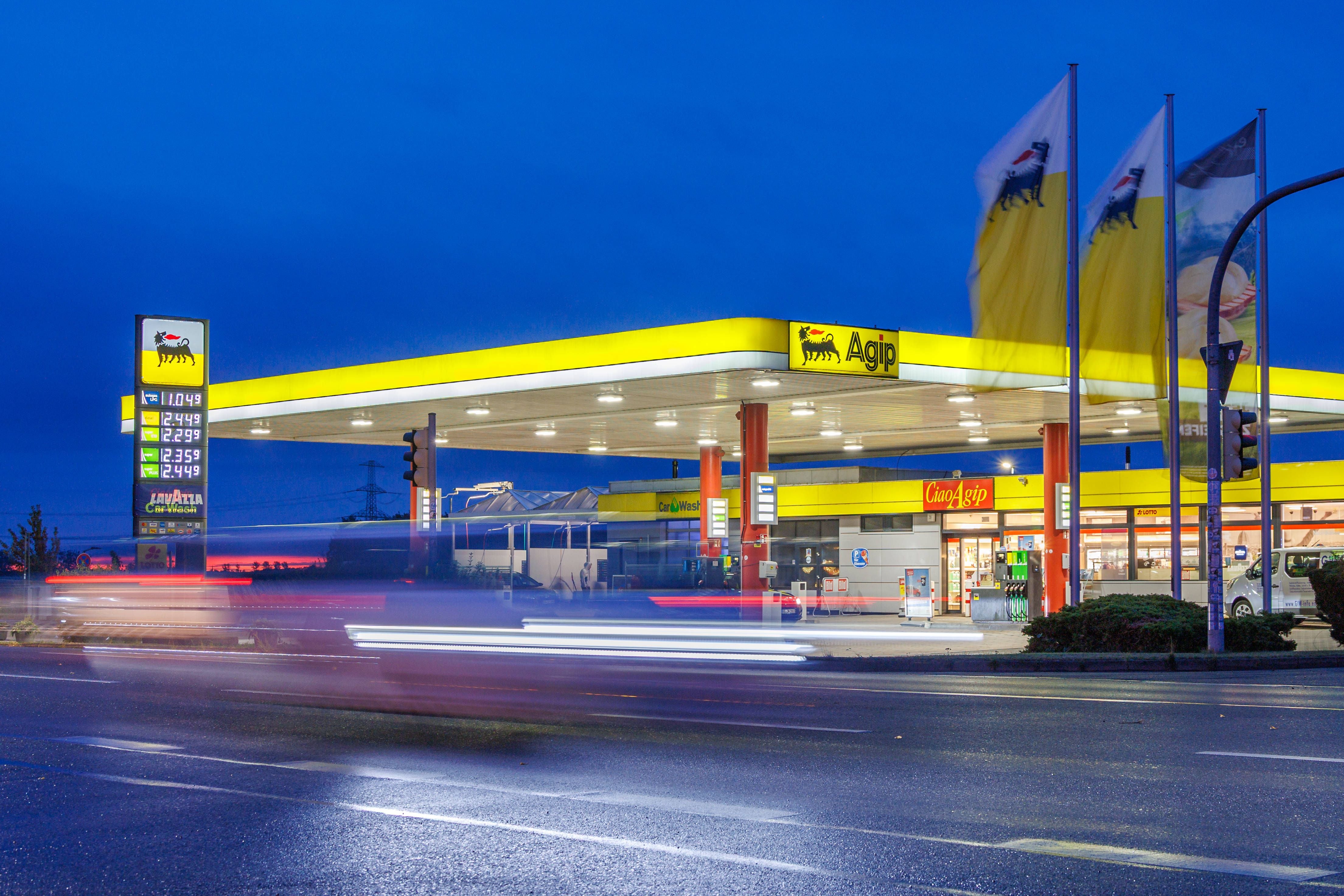 AGIP Tankstelle in Pasewalk bei Nacht mit beleuchteter Preistafel und vorbeifahrenden Autos.