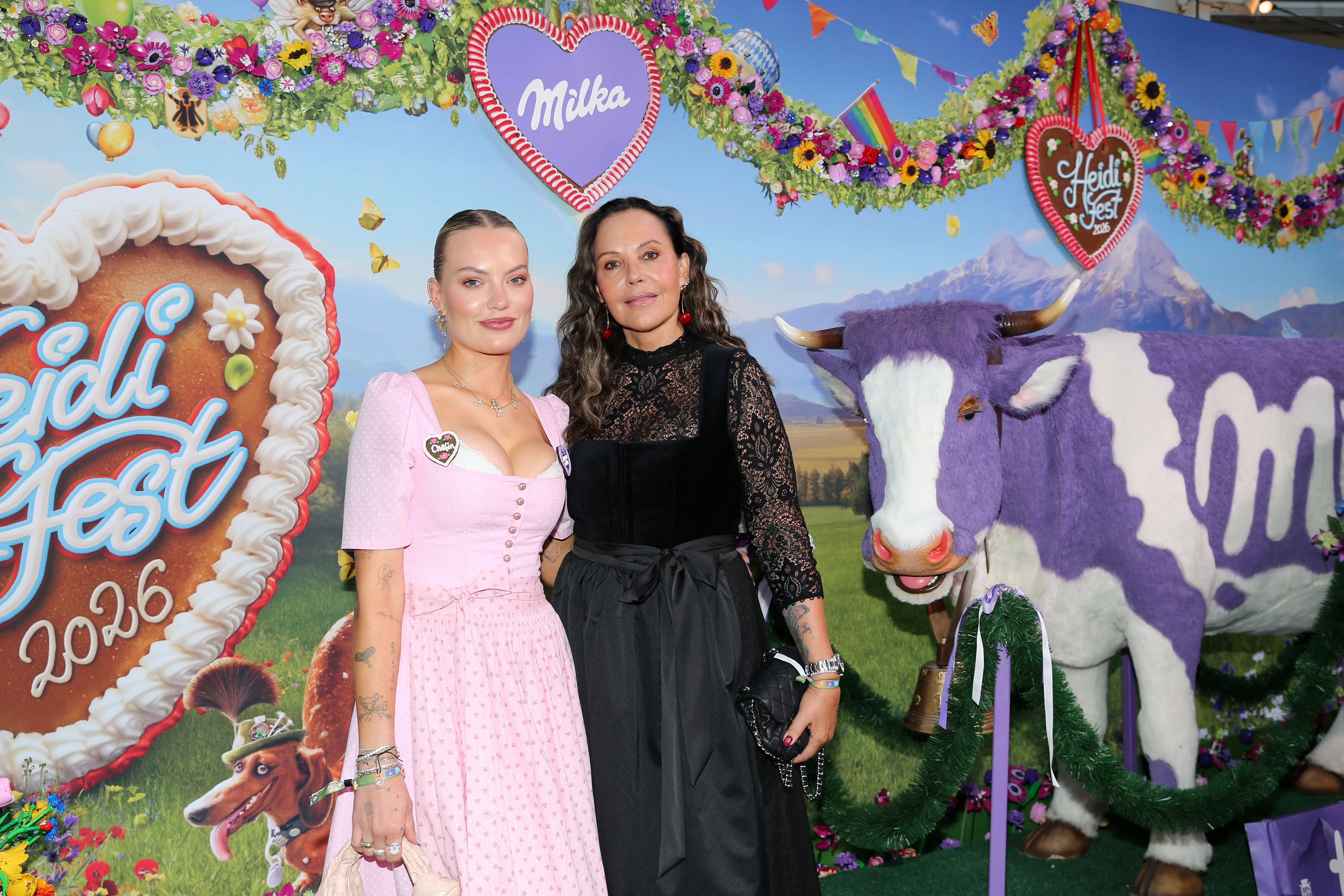 Zwei Frauen posieren vor einer lila Milka-Kuh und festlicher Deko auf dem HeidiFest.