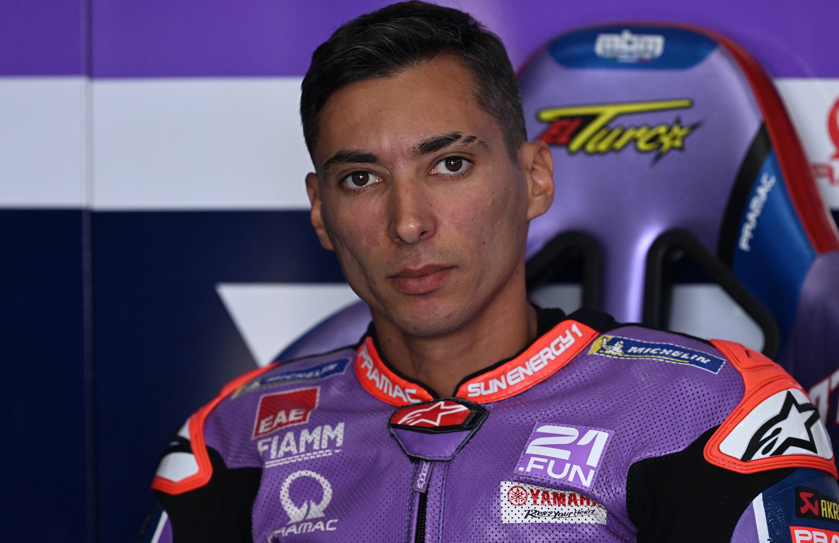 Ein Motorradrennfahrer im lila Rennanzug sitzt im Team-Garage vor dem MotoGP-Aragon-Grand-Prix.