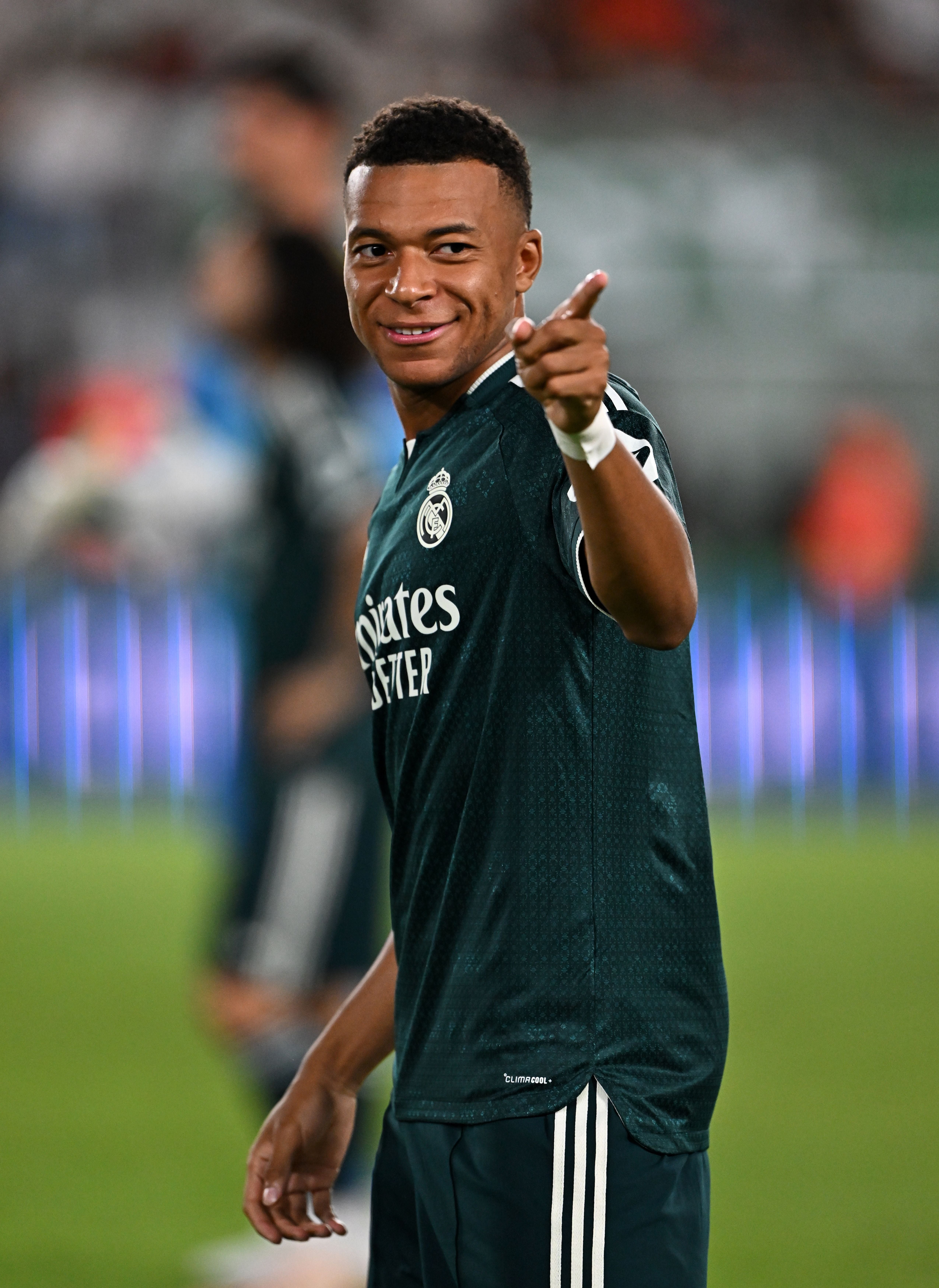 Ein Fußballspieler von Real Madrid lächelt und zeigt mit dem Finger in die Kamera.