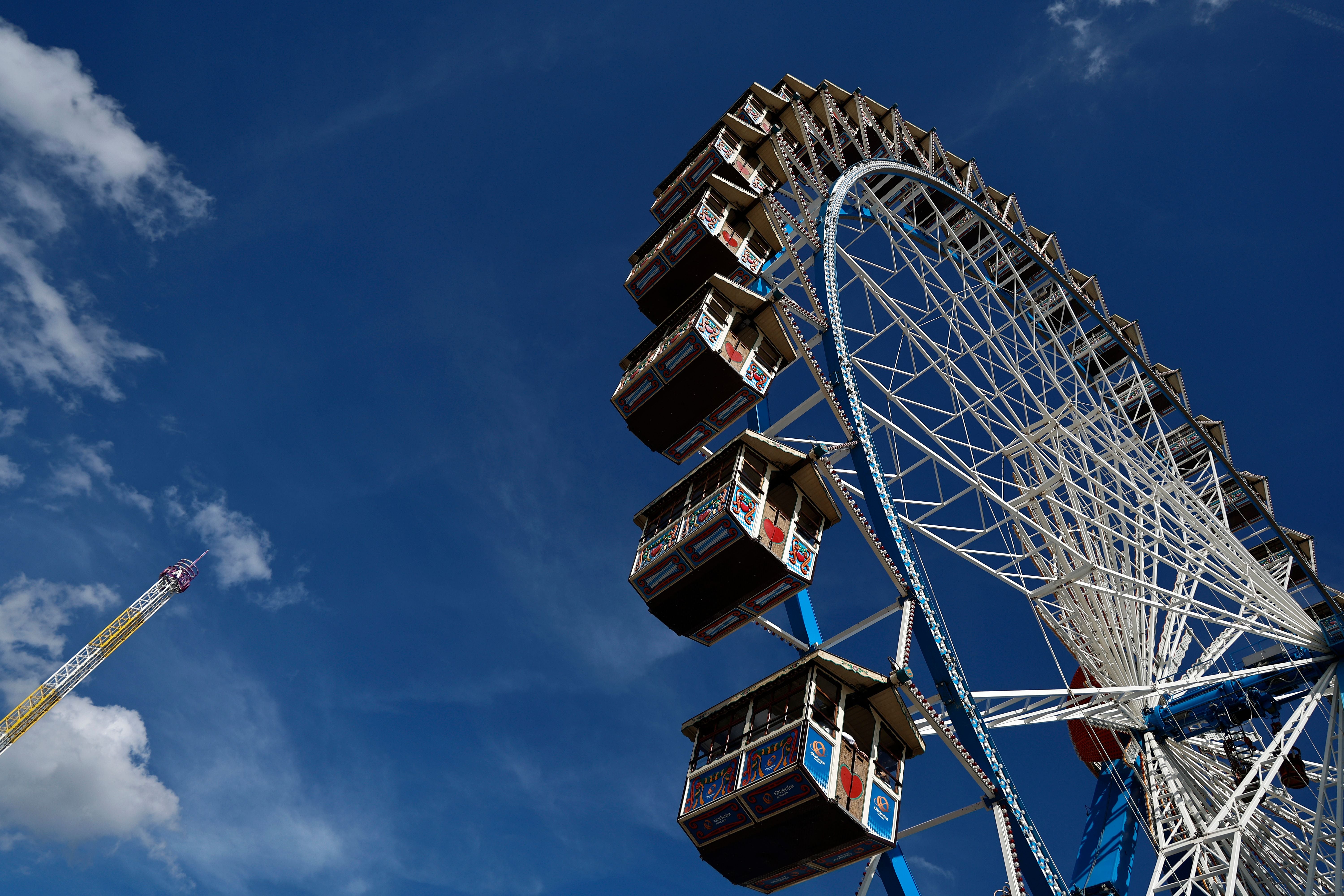 Riesenrad mit dekorierten Gondeln vor blauem Himmel auf dem Oktoberfest in München.
