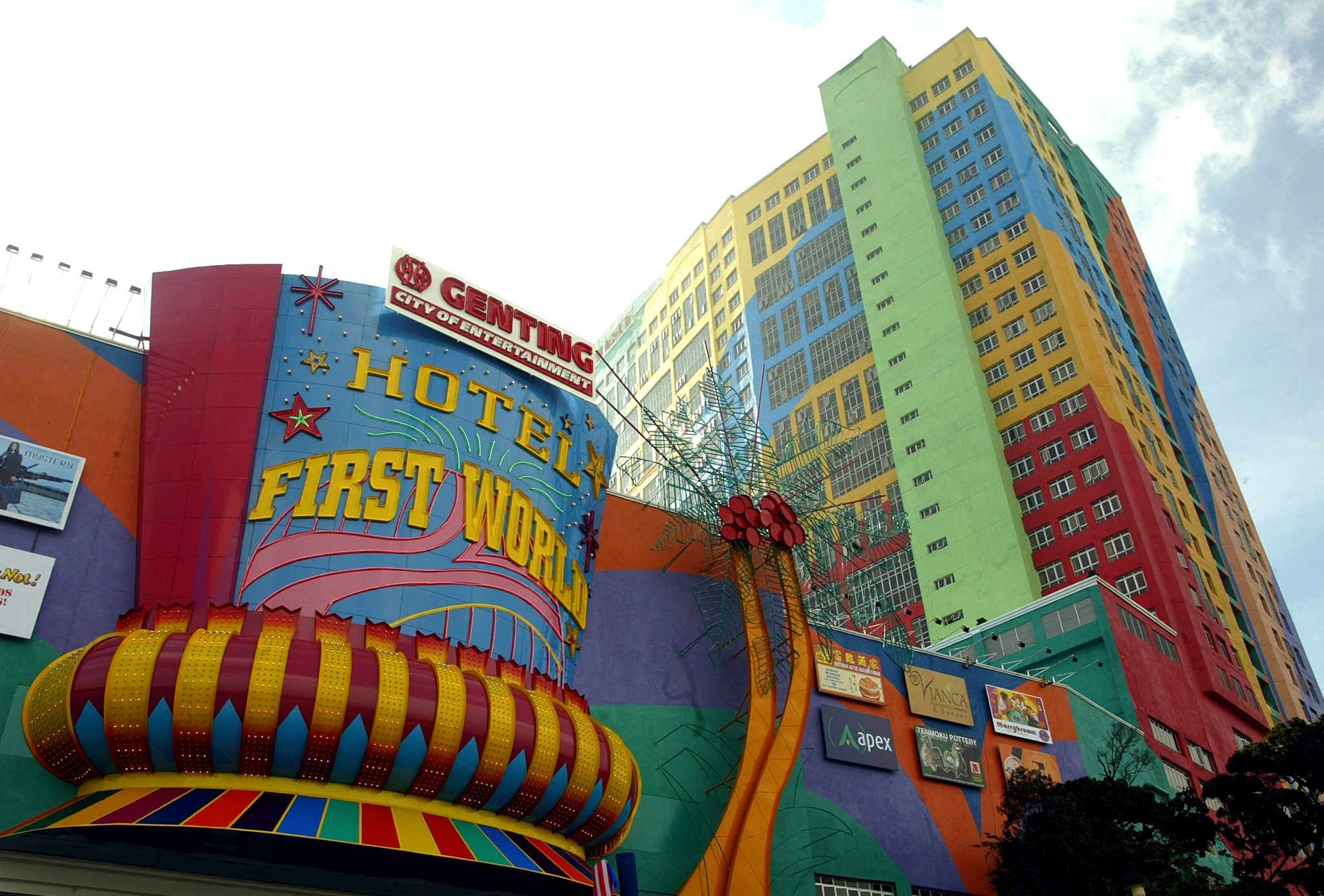 Buntes Hochhaus des First World Hotels in Genting Highlands mit auffälligen Fassaden und Schildern.