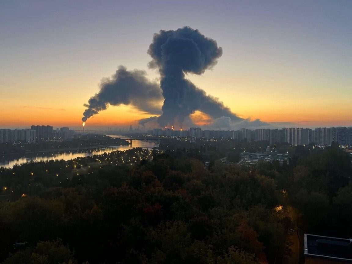 Große dunkle Rauchwolke über Moskau bei Sonnenuntergang, im Vordergrund Fluss und Stadt.
