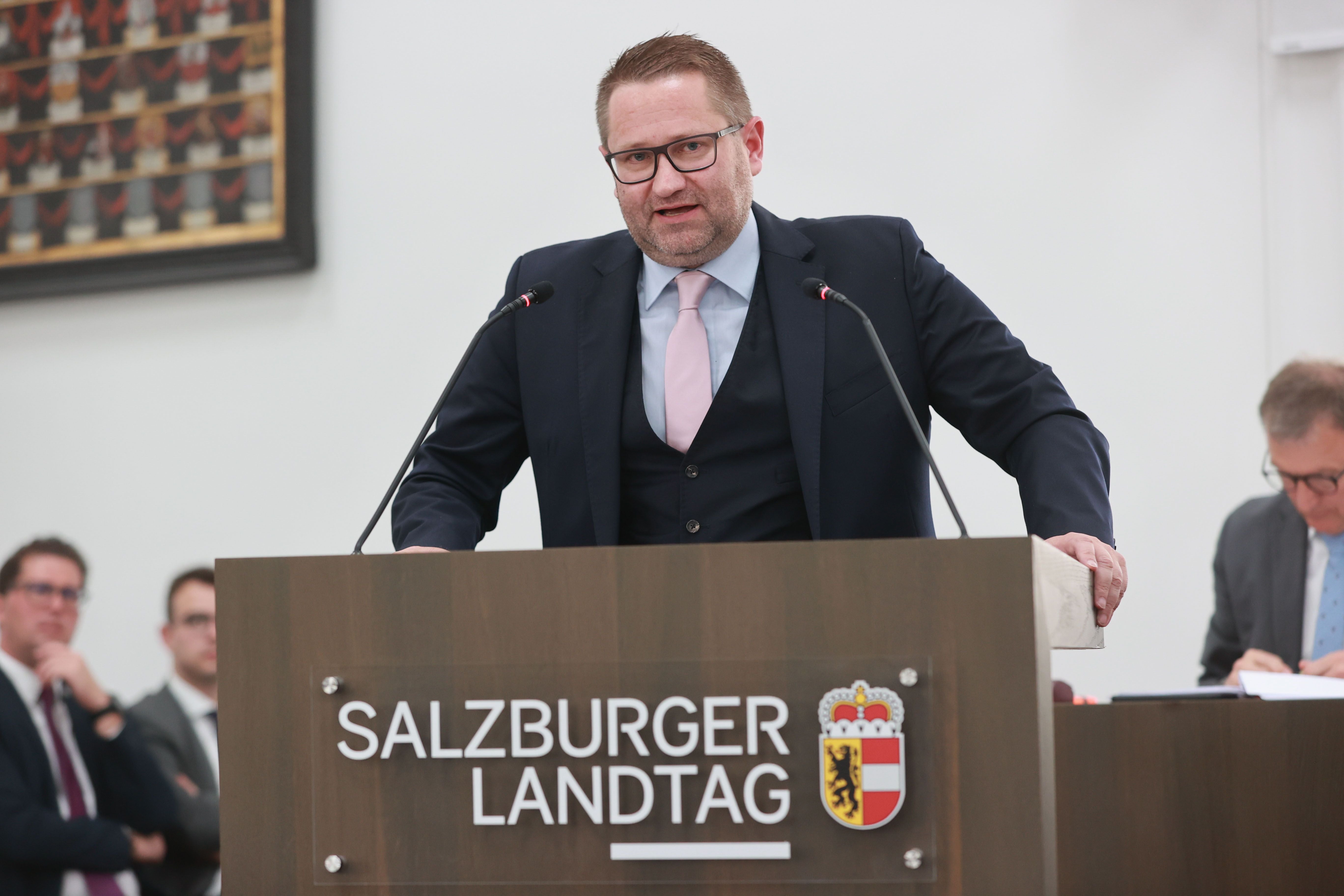 Ein Mann spricht am Rednerpult im Salzburger Landtag während einer Sitzung.