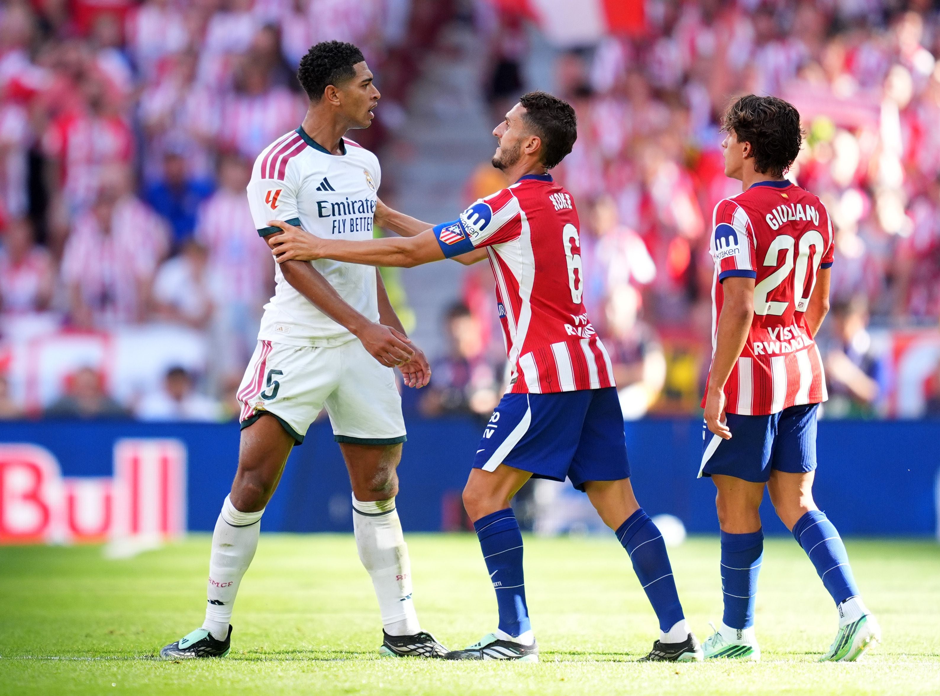 Koke von Atletico hält Jude Bellingham von Real Madrid während eines Fußballspiels zurück.