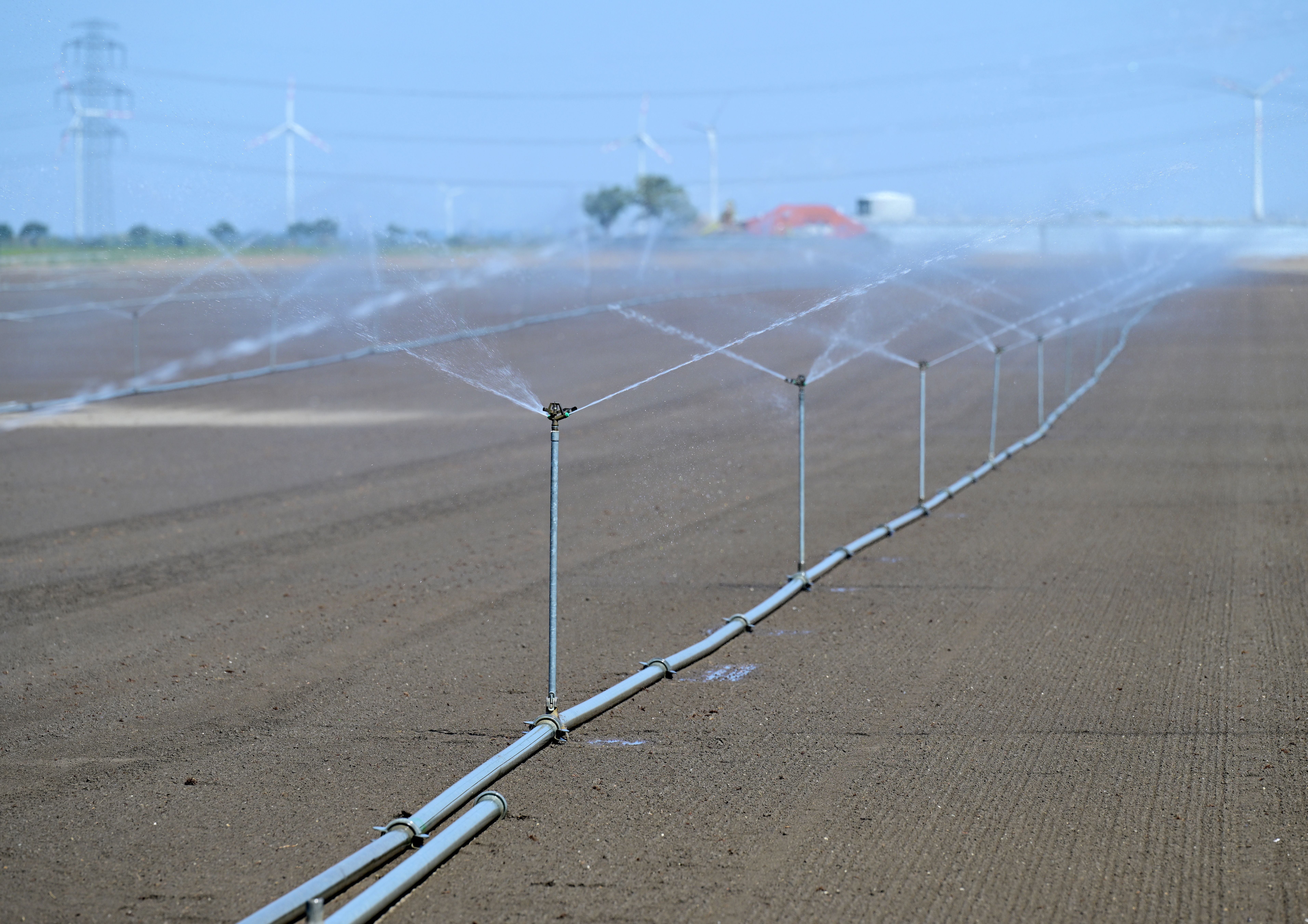 Bewässerungsanlage sprüht Wasser auf ein trockenes Feld bei Probstdorf, Österreich.