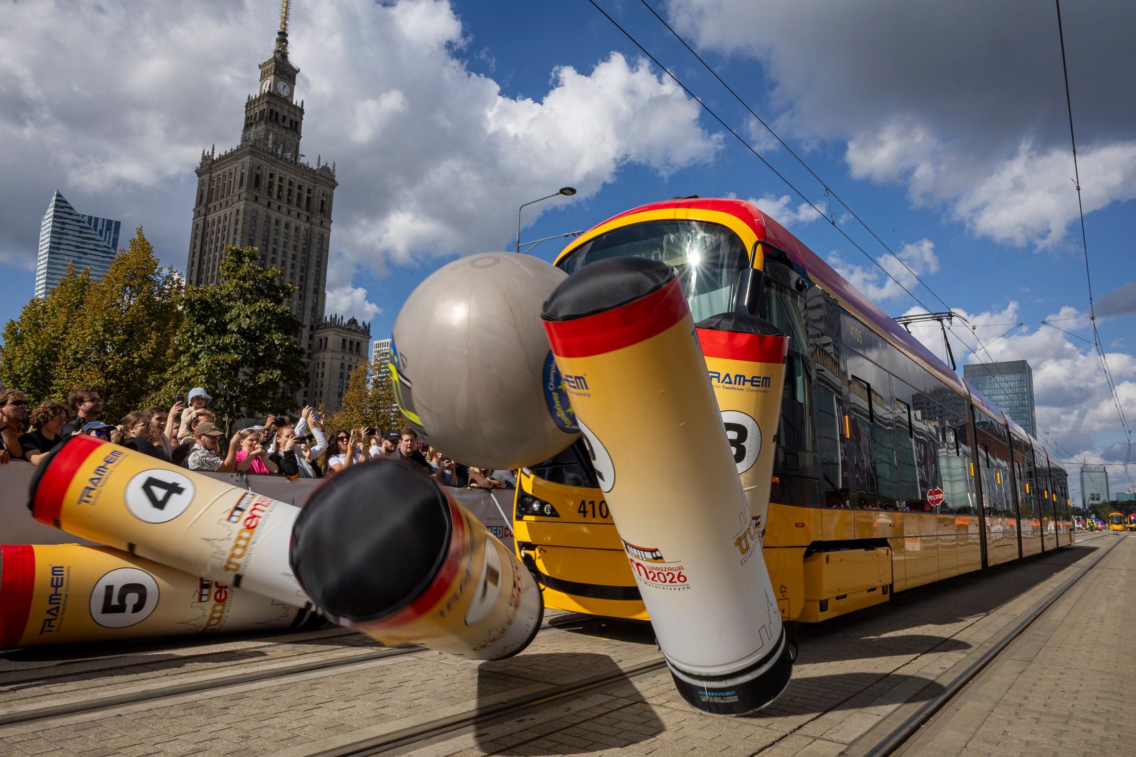 Eine Straßenbahn stößt bei einer Veranstaltung in Warschau auf riesige Bowling-Kegel.