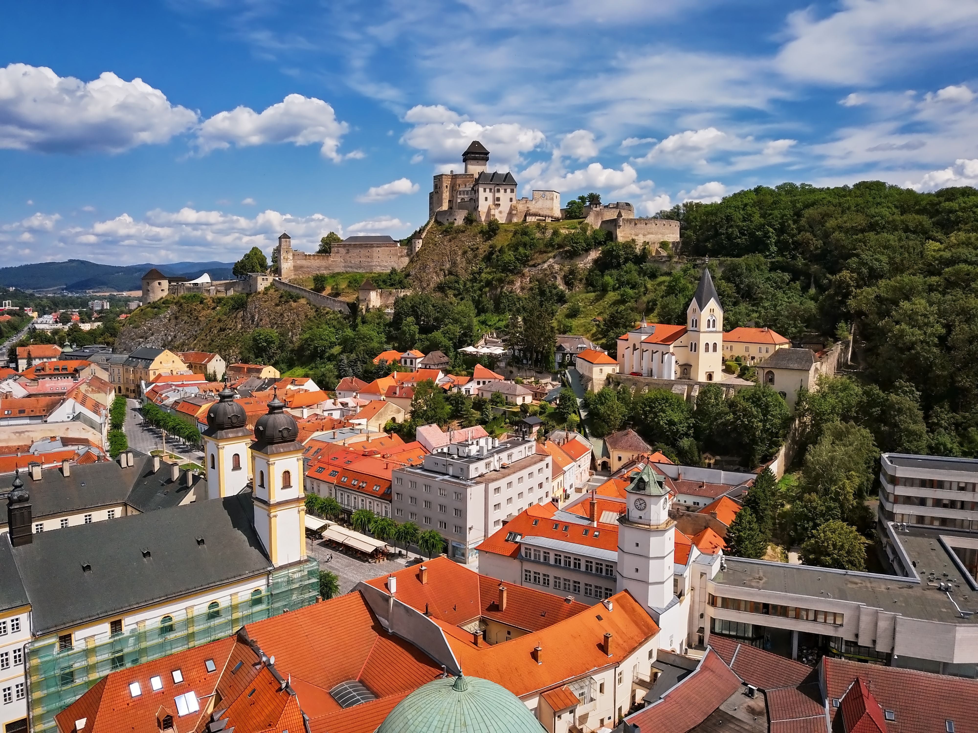 Luftaufnahme von Trencín in der Slowakei mit Burg und Altstadt bei sonnigem Wetter.