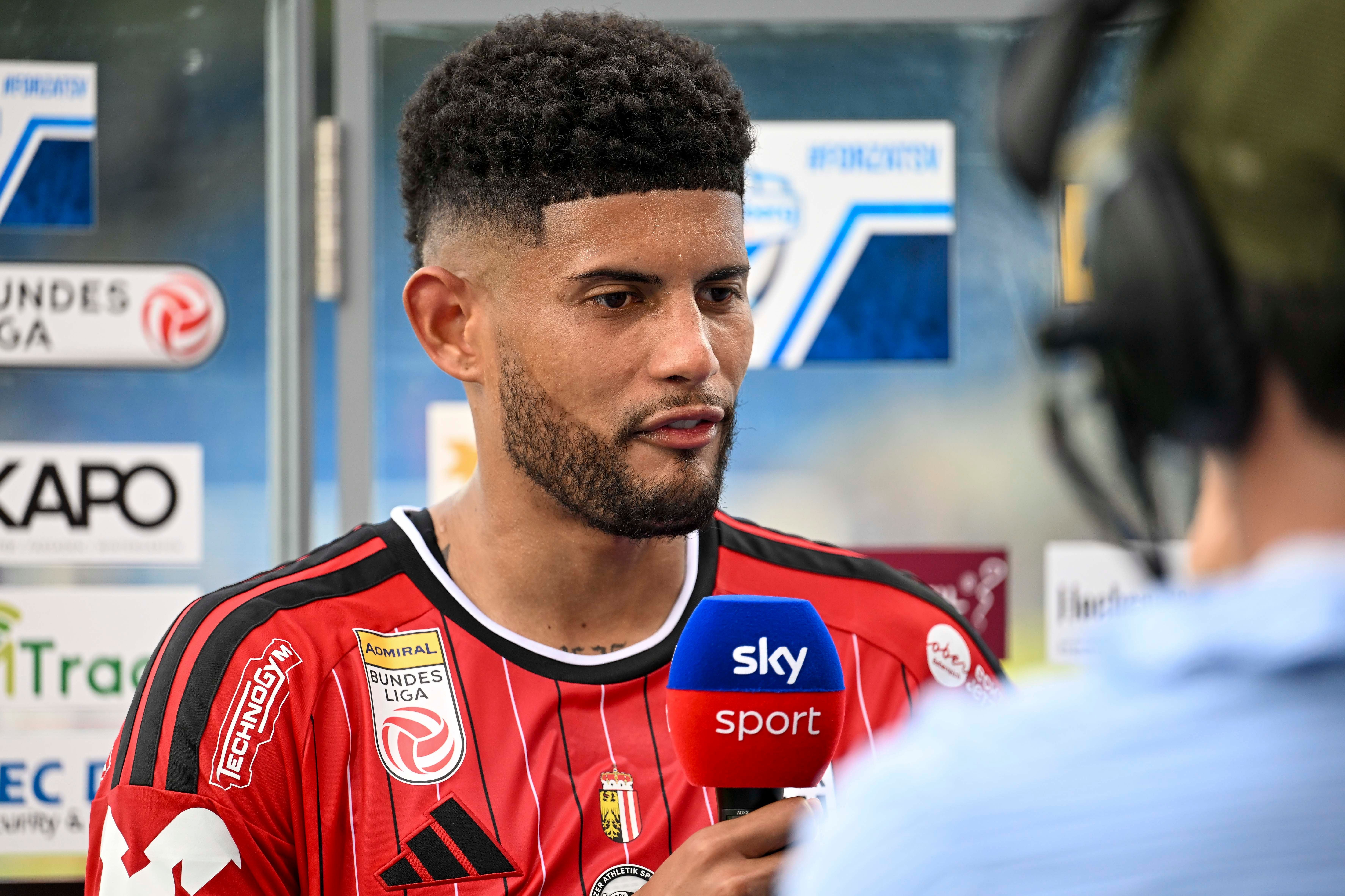 Ein Fußballspieler im LASK-Trikot gibt ein Interview mit einem Sky Sport Mikrofon.