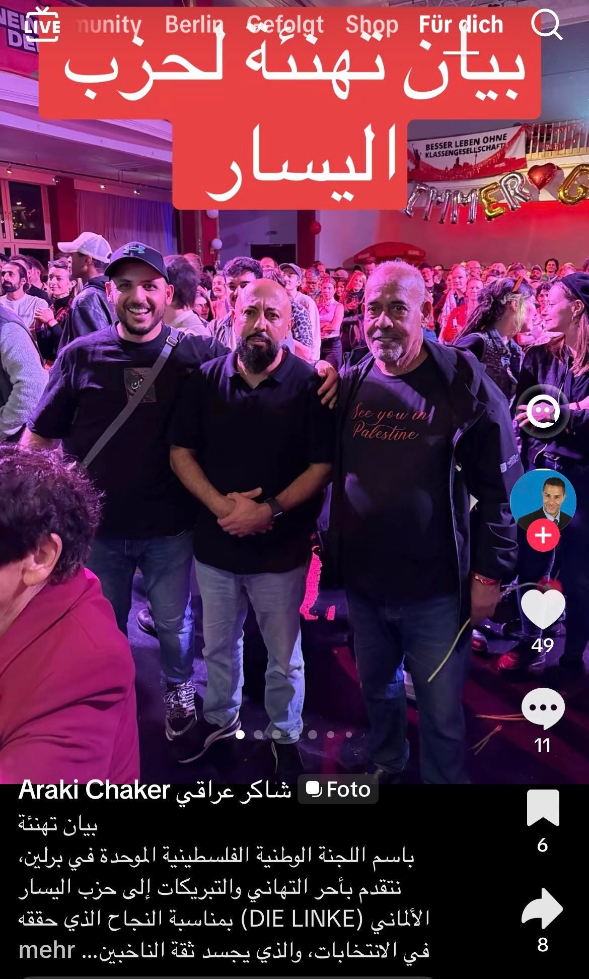 Drei Männer posieren bei einer Feier, im Hintergrund eine Menschenmenge und Banner.