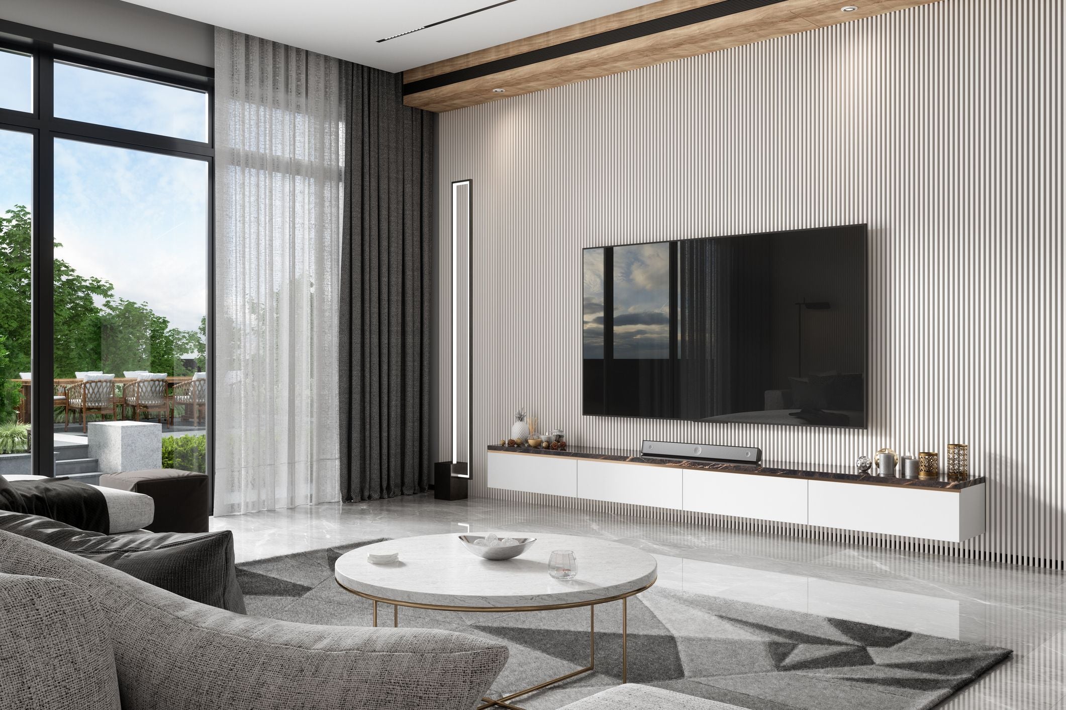 Modernes Wohnzimmer mit Sofa, rundem Couchtisch, großem Fernseher und Blick auf den Garten.