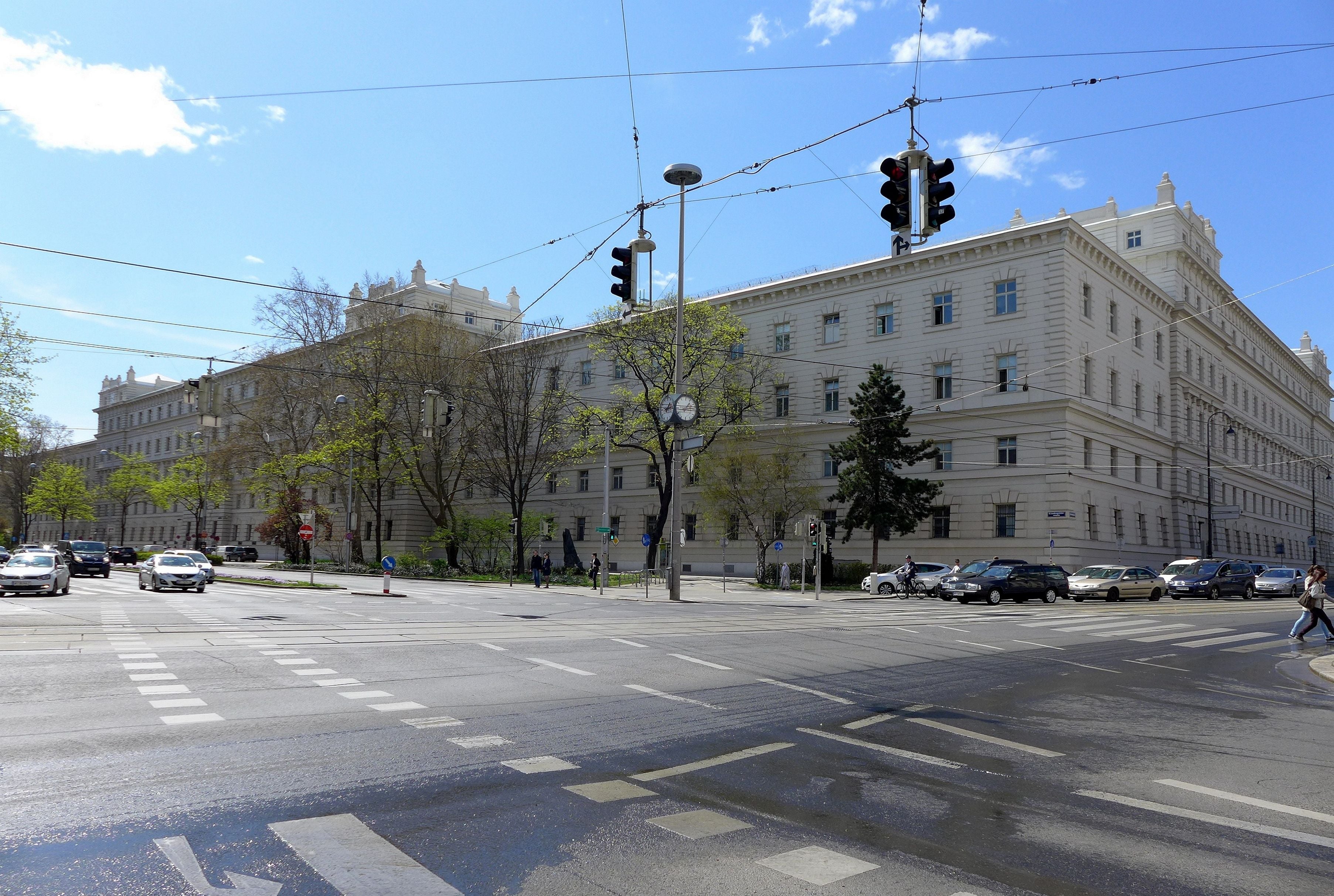 Das Landesgericht für Strafsachen Wien an einer belebten Kreuzung bei Tageslicht.
