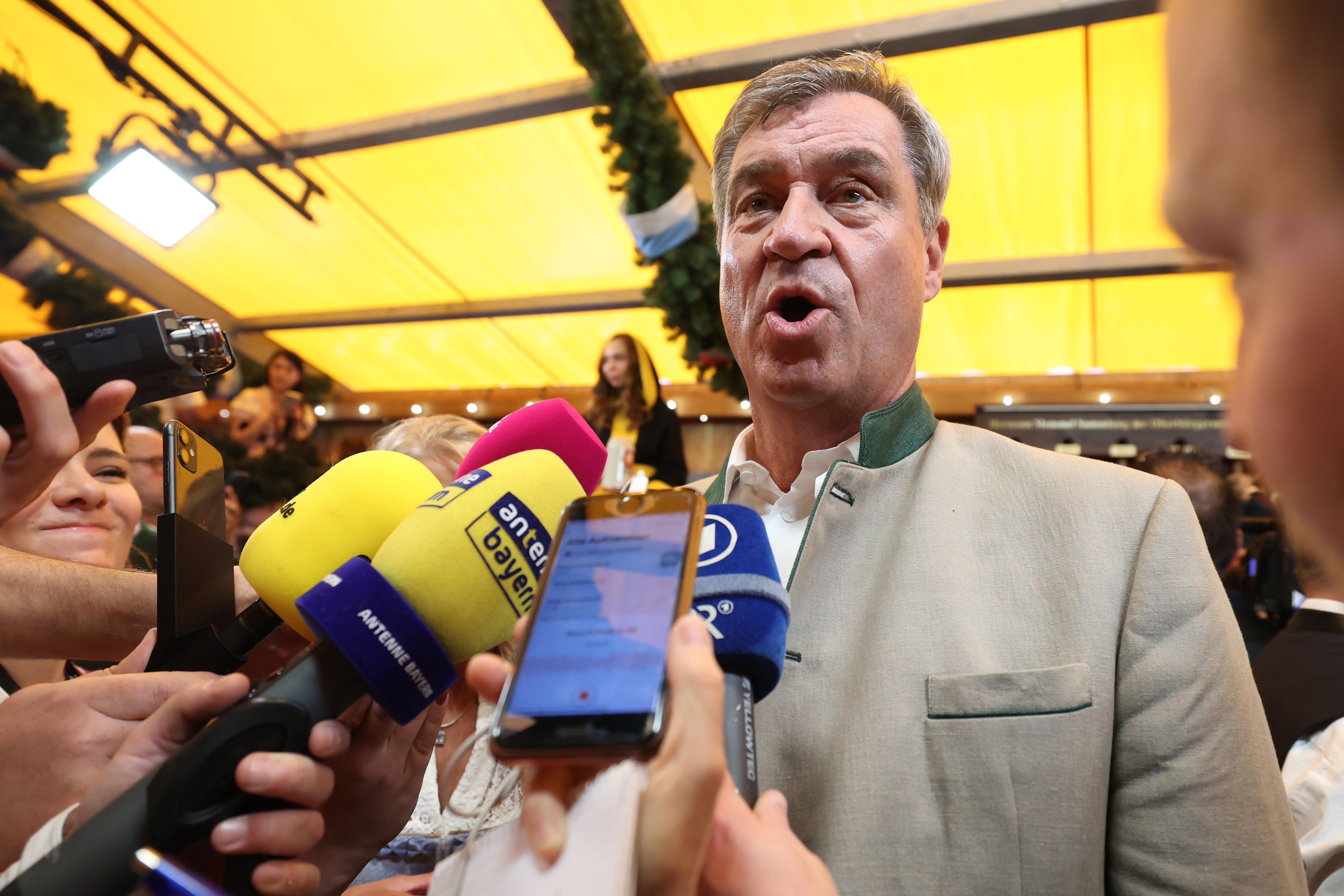 Markus Söder gibt ein Interview vor Mikrofonen auf dem Oktoberfest in München.
