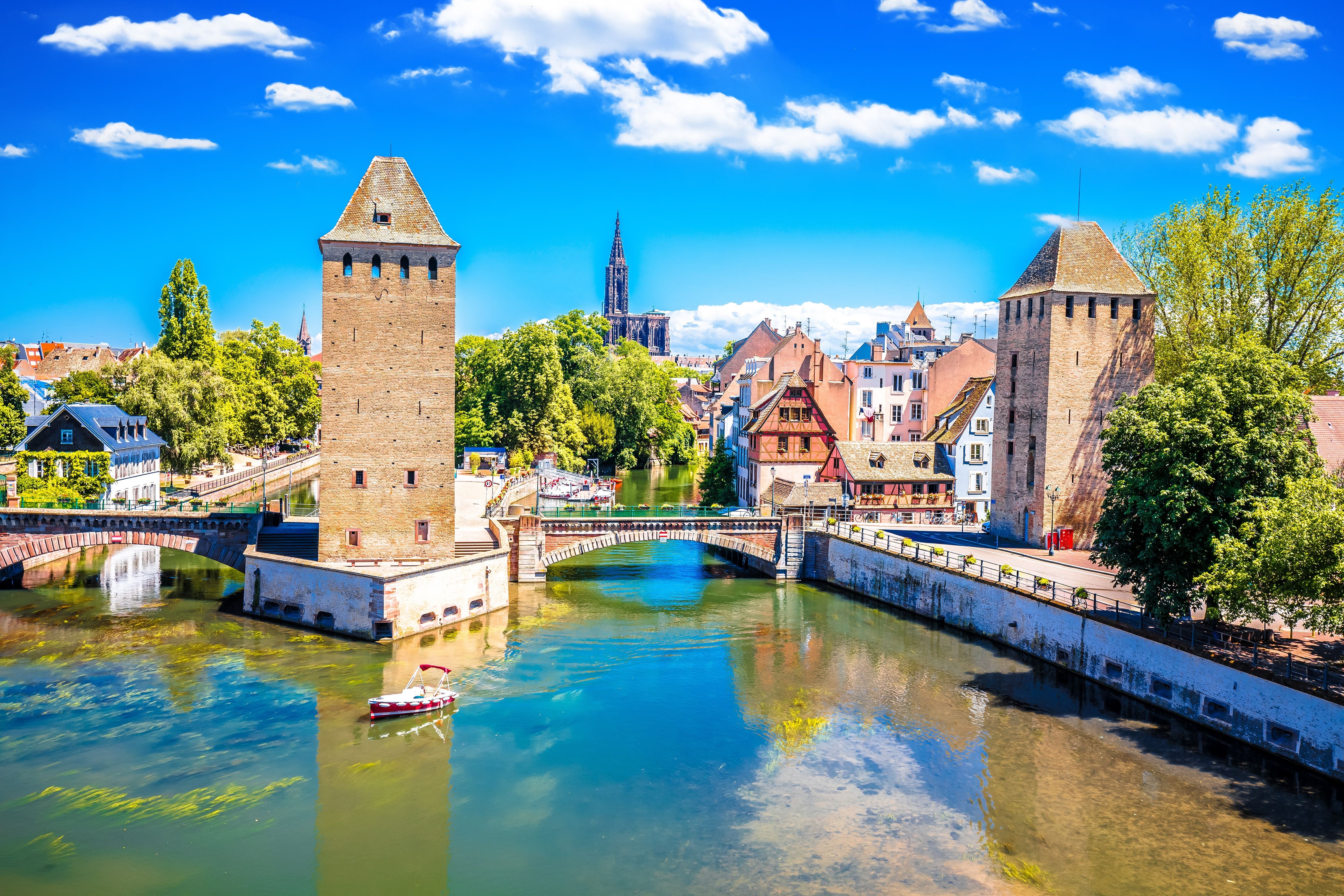 Blick auf den Barrage Vauban und die Kathedrale in Straßburg am Fluss bei sonnigem Wetter.