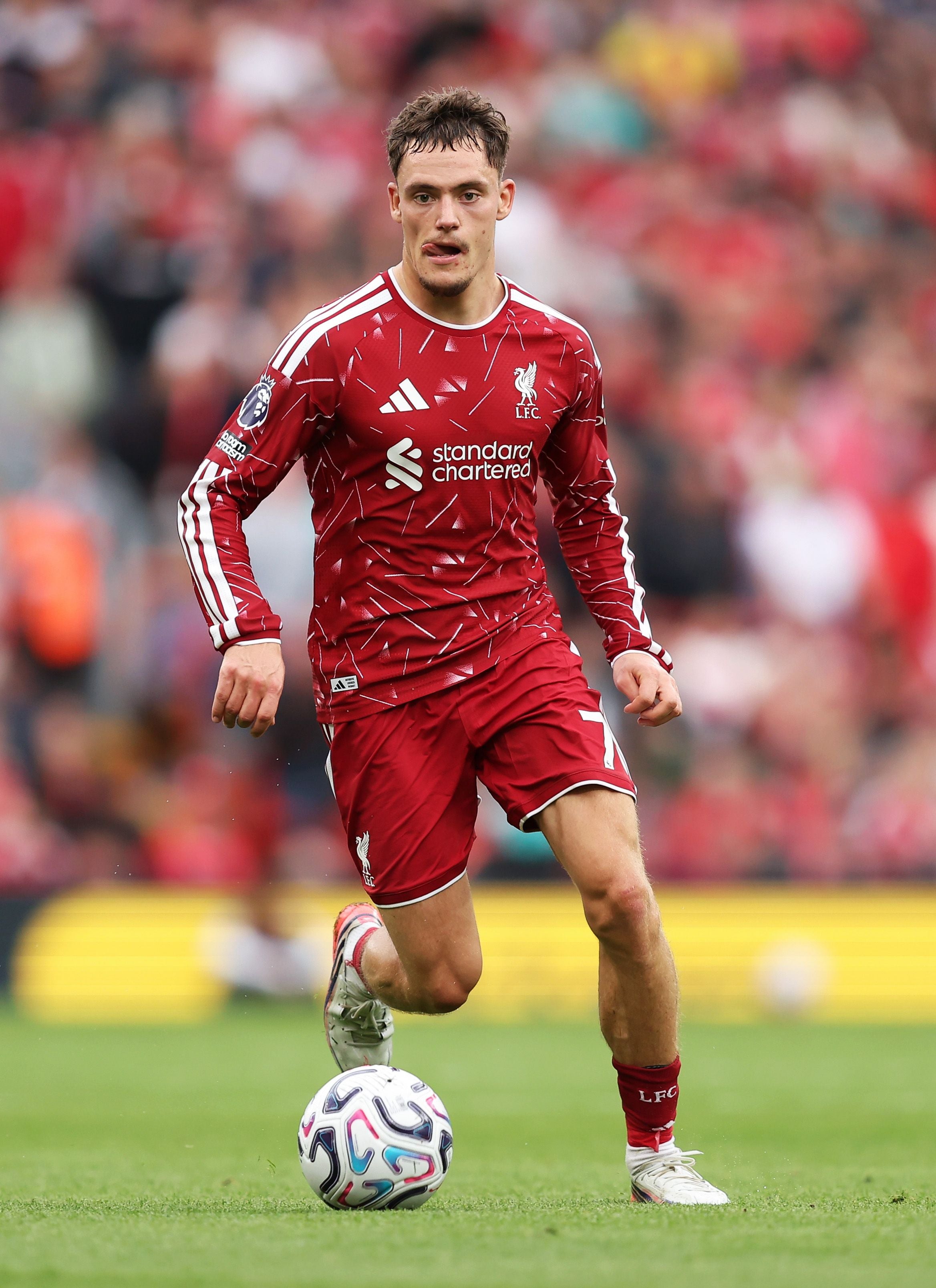 Ein Fußballspieler im roten Liverpool-Trikot läuft mit dem Ball über das Spielfeld.