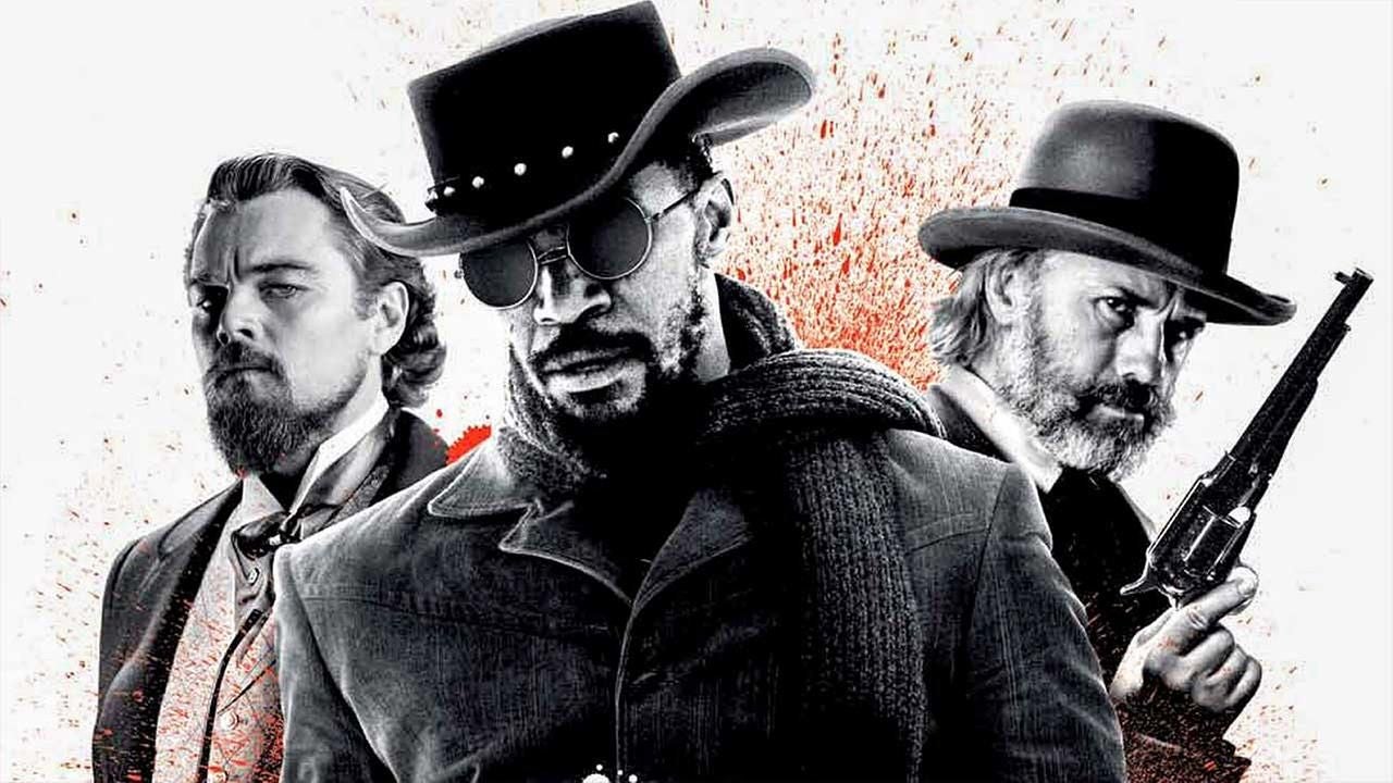 Drei Männer im Western-Look, einer mit Hut und Sonnenbrille, zwei mit Hüten und ernsten Blicken.