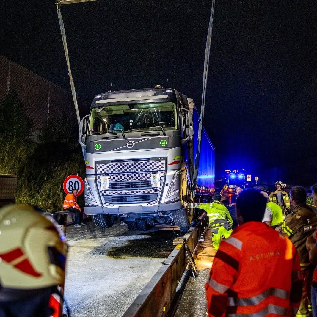 Großer LKW wird nachts nach einem Unfall auf der A10 bei Flachgau von Einsatzkräften geborgen.