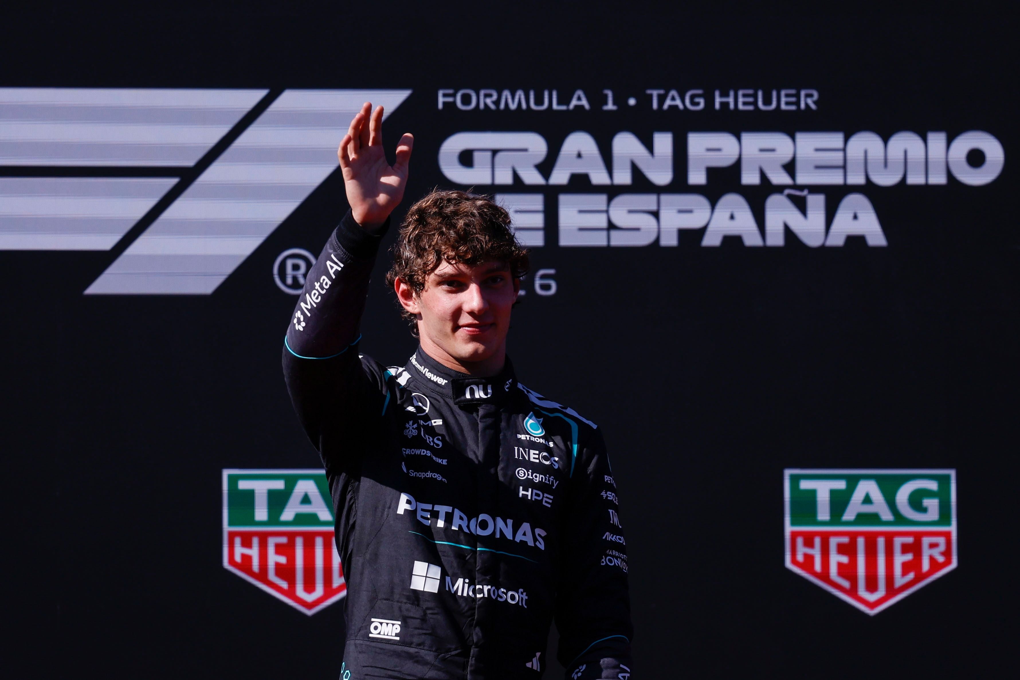 Ein Rennfahrer im Mercedes-Overall winkt nach einem Sieg beim Großen Preis von Spanien.
