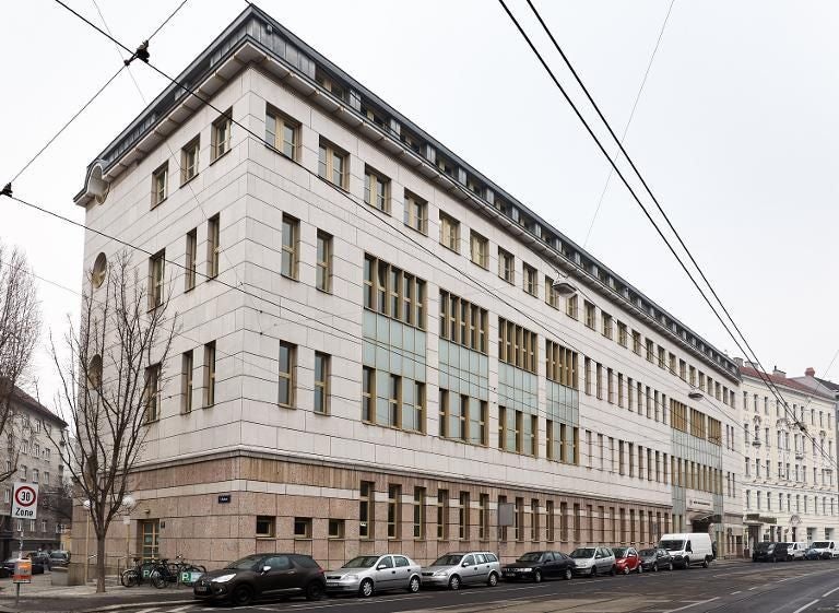 Modernes, mehrstöckiges Gerichtsgebäude mit vielen Fenstern an einer Straße in Wien.
