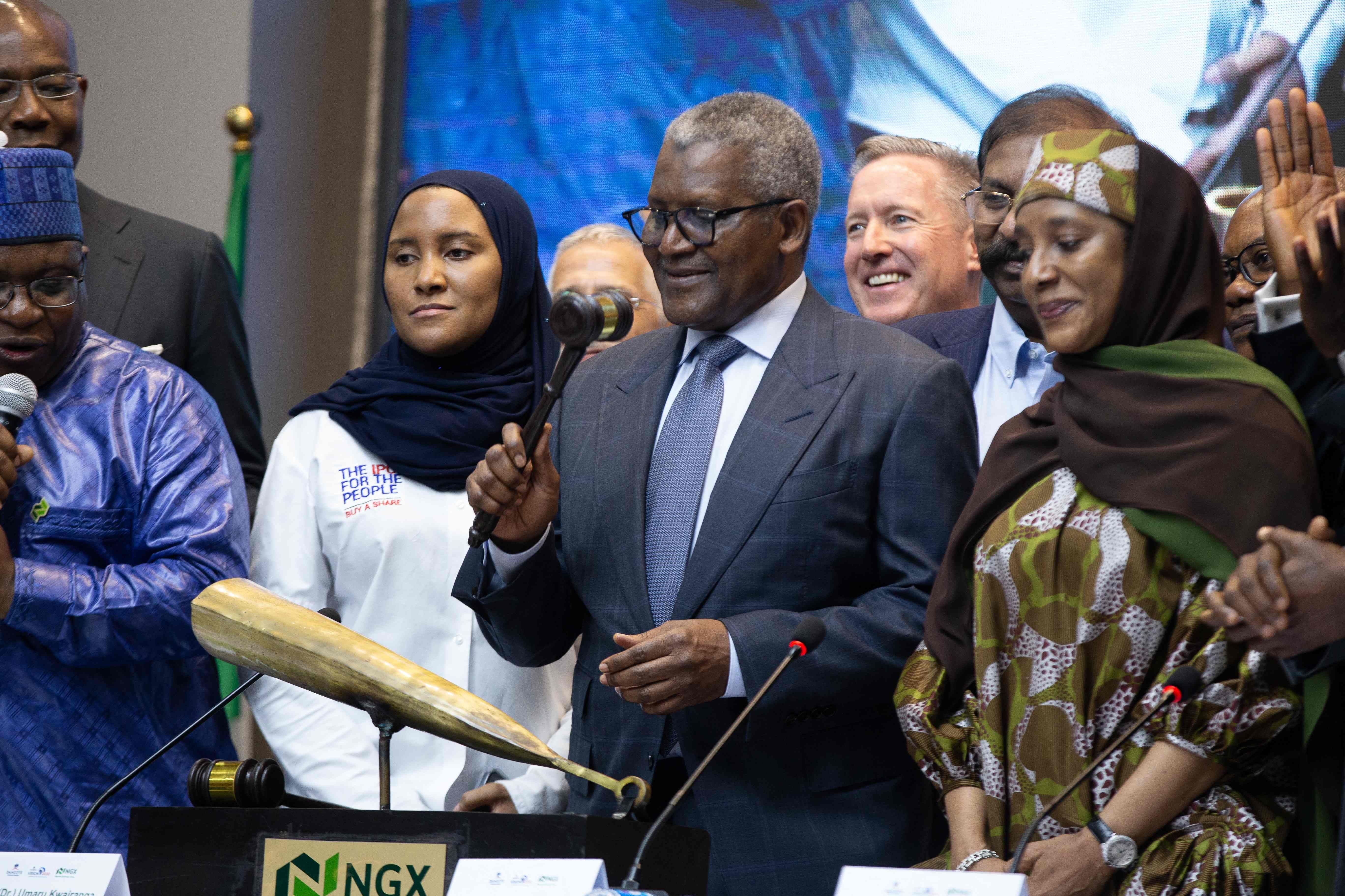 Aliko Dangote schlägt von Menschen umgeben den Börsengong bei einem IPO-Event in Lagos, Nigeria.