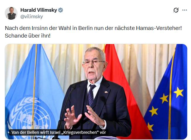 Ein älterer Mann spricht am Rednerpult vor Flaggen der UNO, Österreichs und der EU.