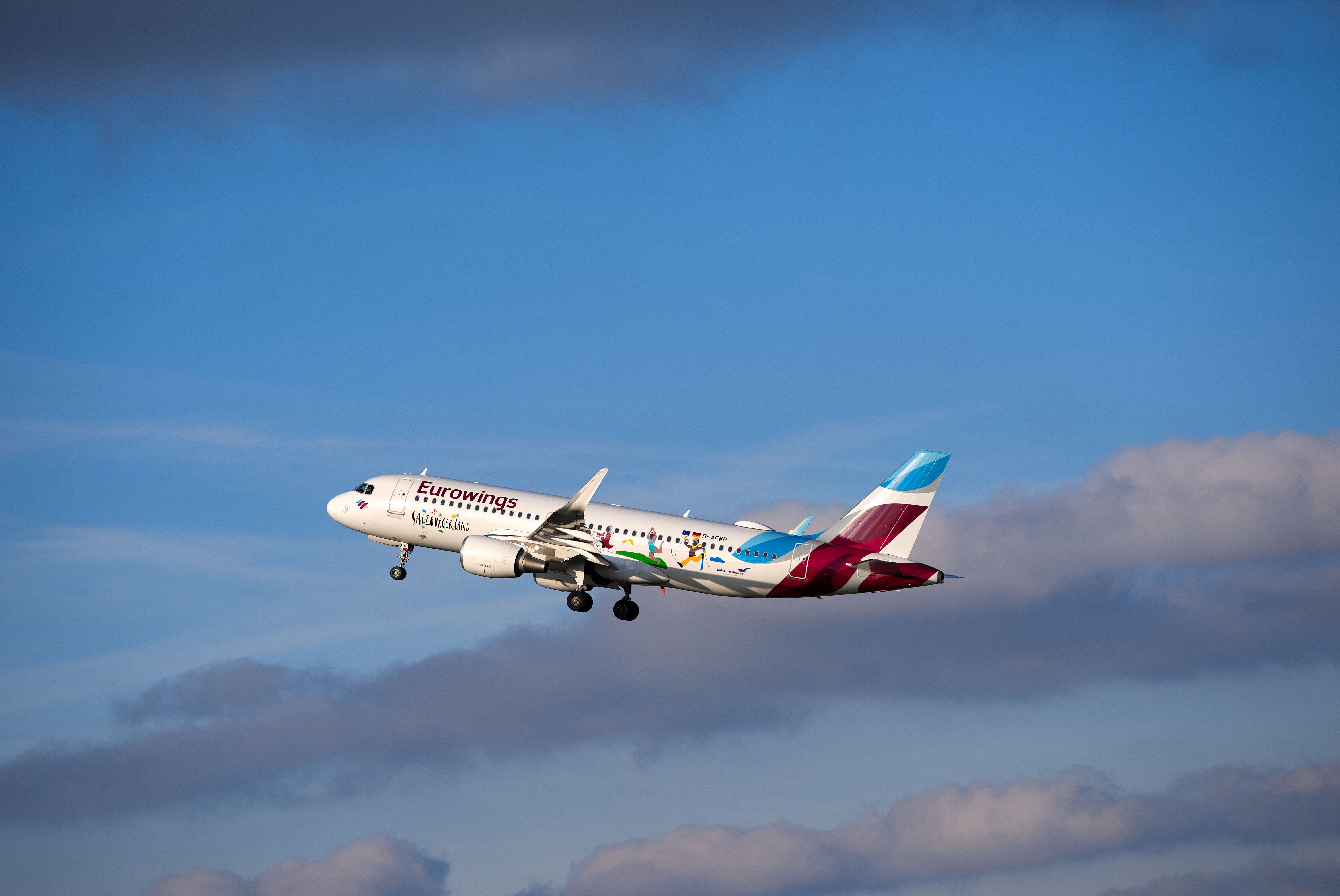 Ein Eurowings Airbus A320 hebt an einem sonnigen Tag am Flughafen Zürich ab.