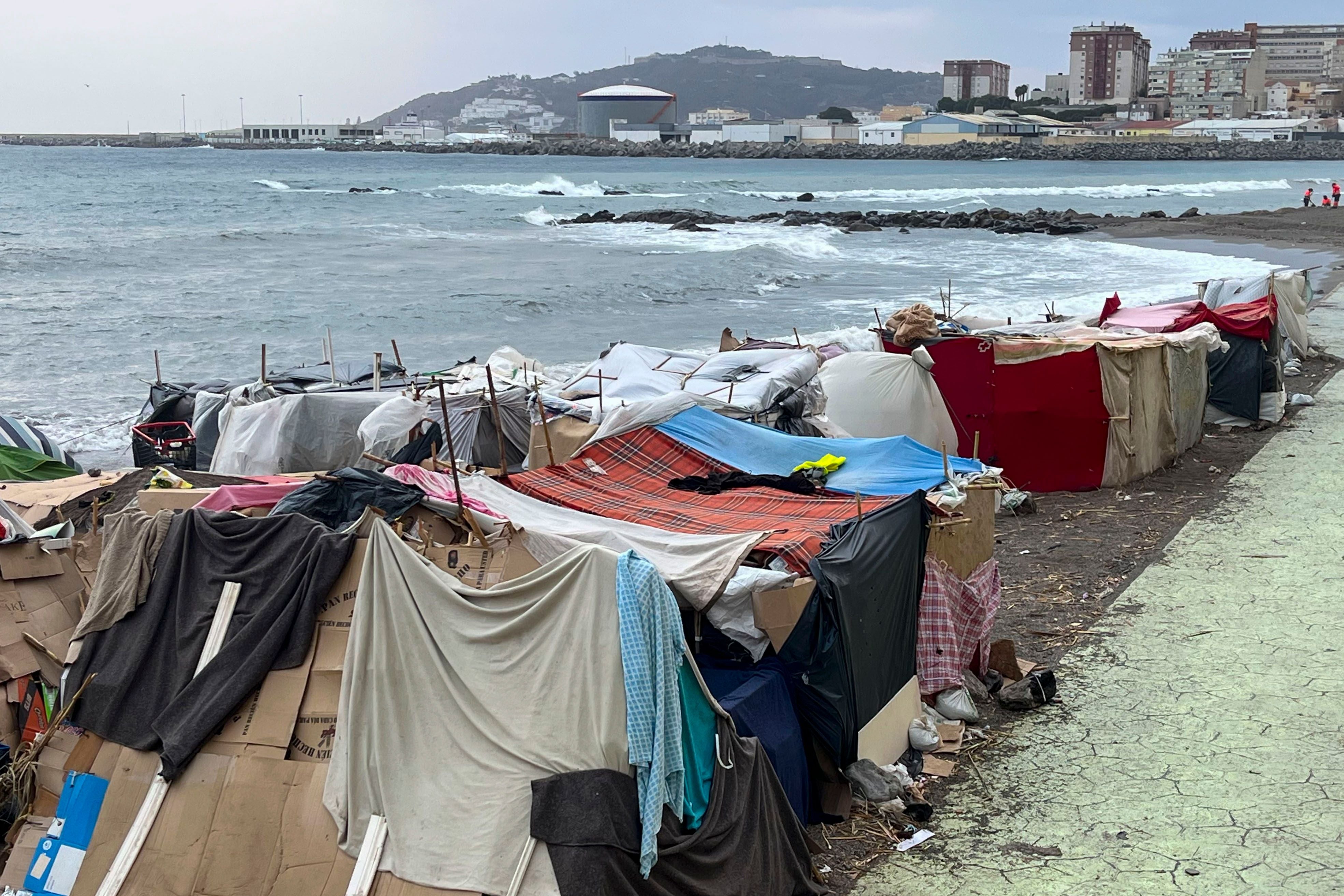 Provisorische Zelte aus Planen und Decken an einem Strandlager für Migranten in Ceuta, Spanien.