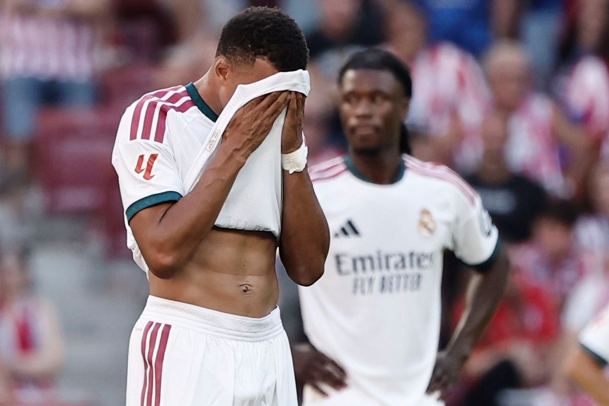 Ein Fußballspieler von Real Madrid bedeckt sein Gesicht mit dem Trikot, ein Mitspieler steht im Hintergrund.
