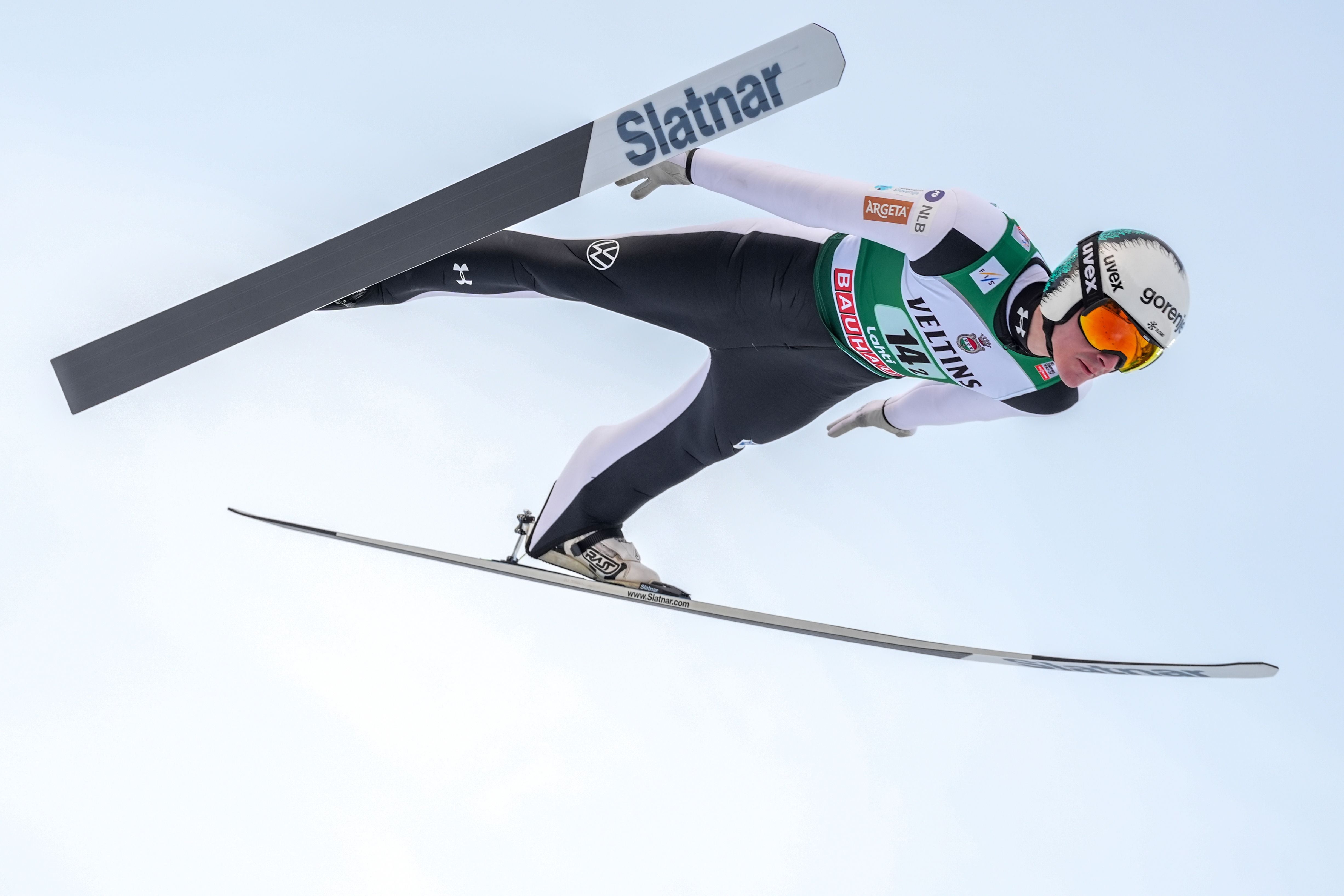 Skispringer Domen Prevc fliegt in V-Stil-Haltung mit angelegten Skiern durch die Luft.