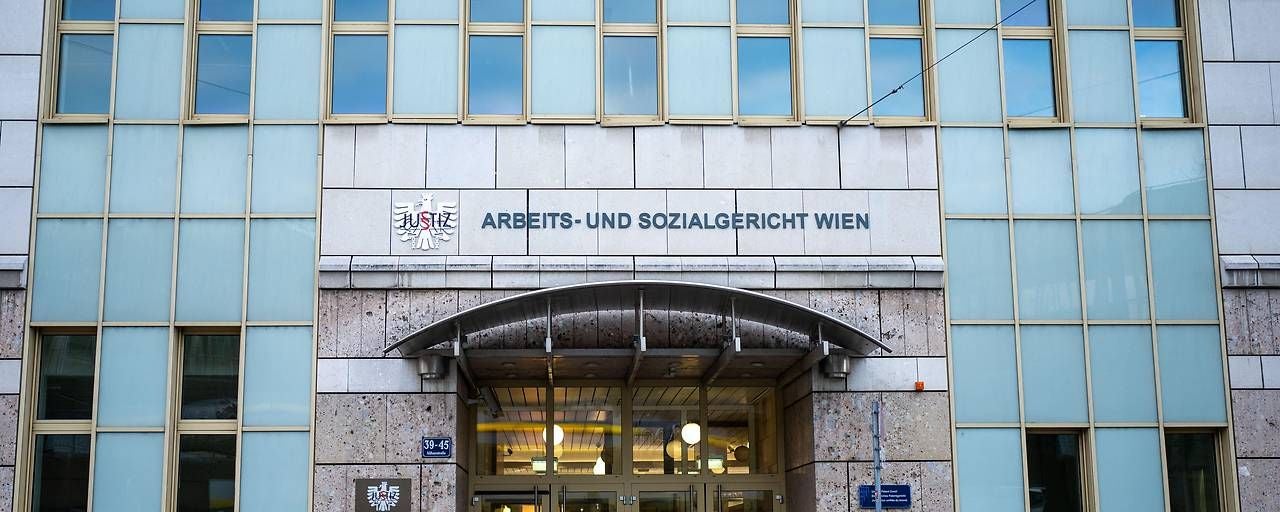 Eingang des Arbeits- und Sozialgerichts Wien mit großer Glasfassade im 9. Bezirk.