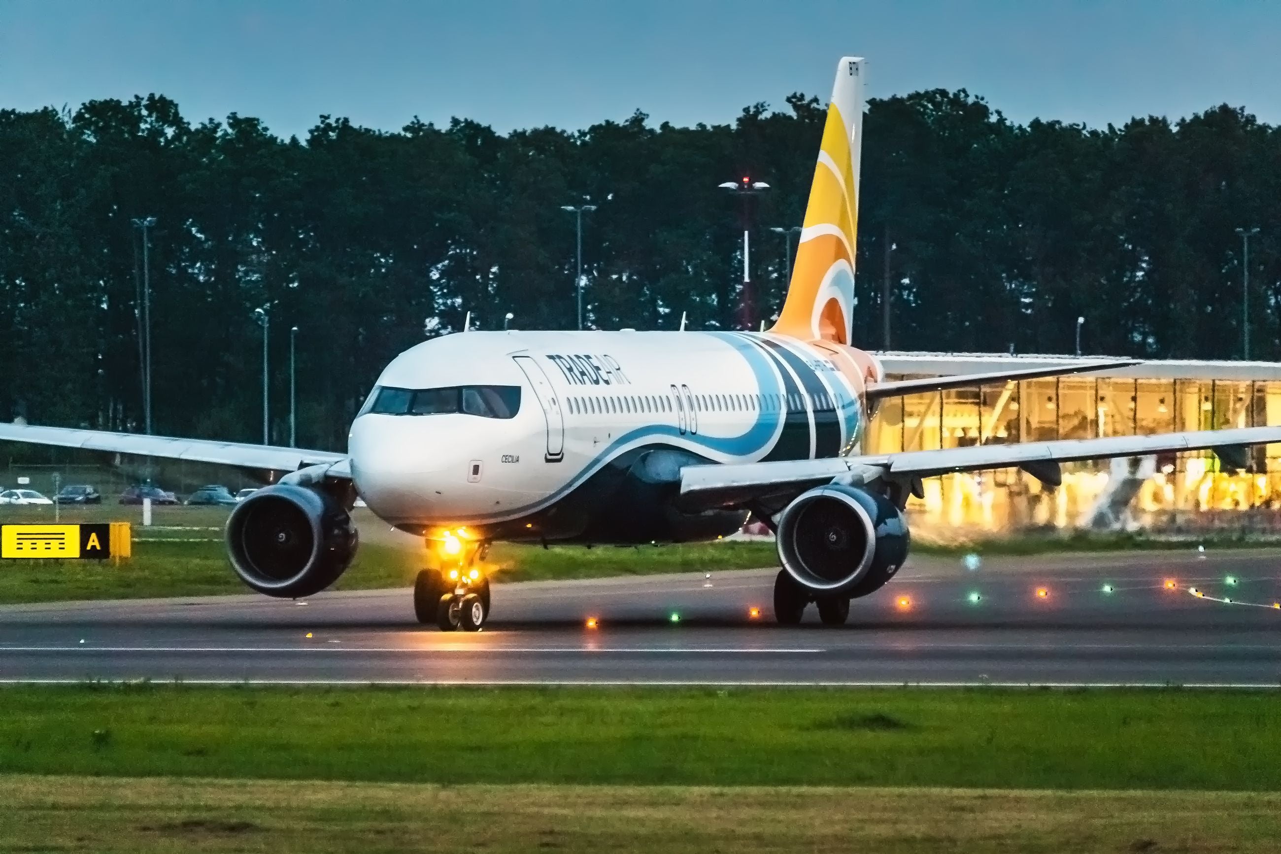 Passagierflugzeug rollt abends auf beleuchtetem Rollfeld am Flughafen Lublin.
