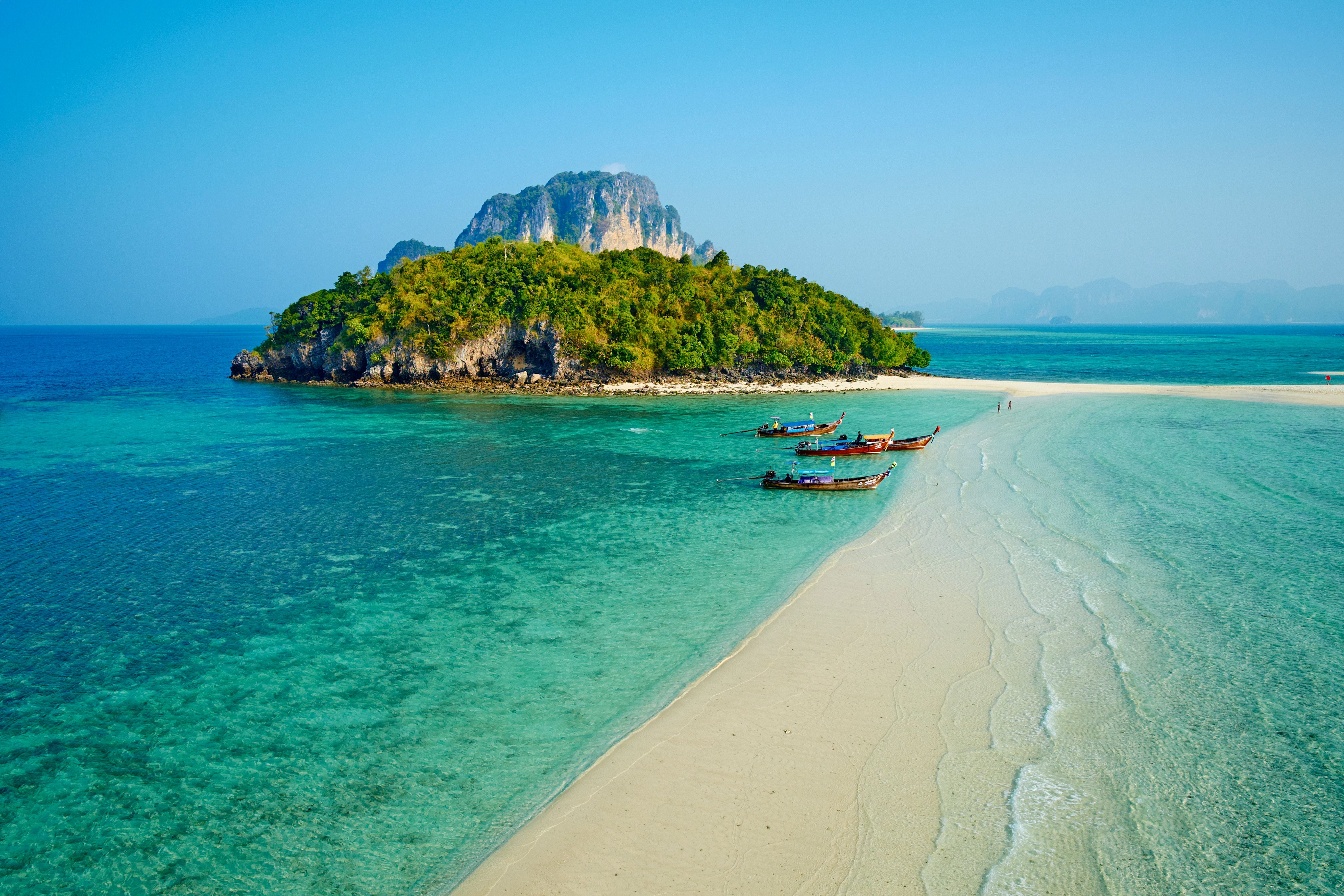 Sandbank verbindet Insel Ko Tub mit türkisblauem Meer und Longtailbooten vor der Küste in Thailand.
