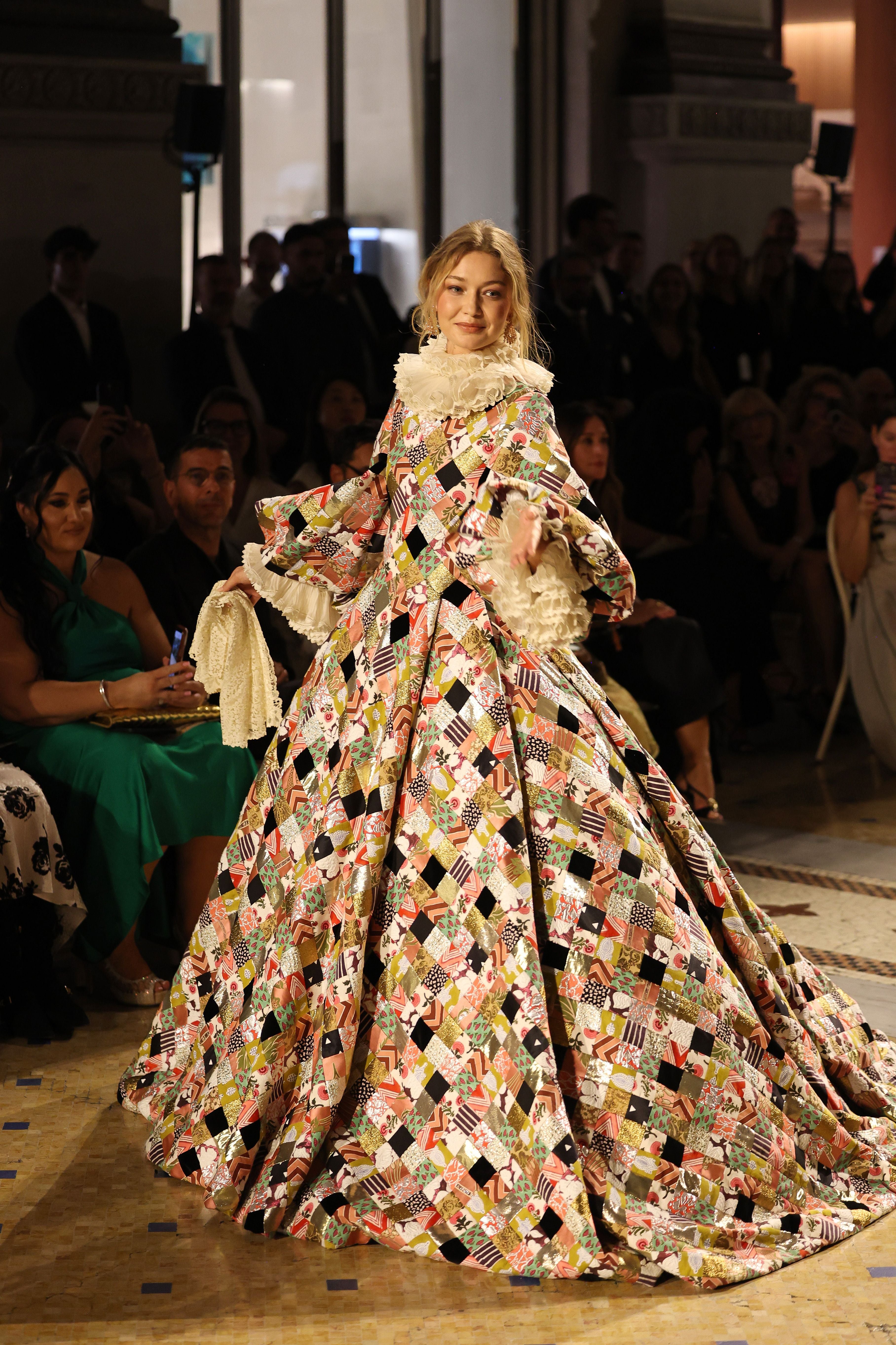 Model präsentiert ein buntes, gemustertes Kleid mit weitem Rock auf einem Laufsteg in Mailand.
