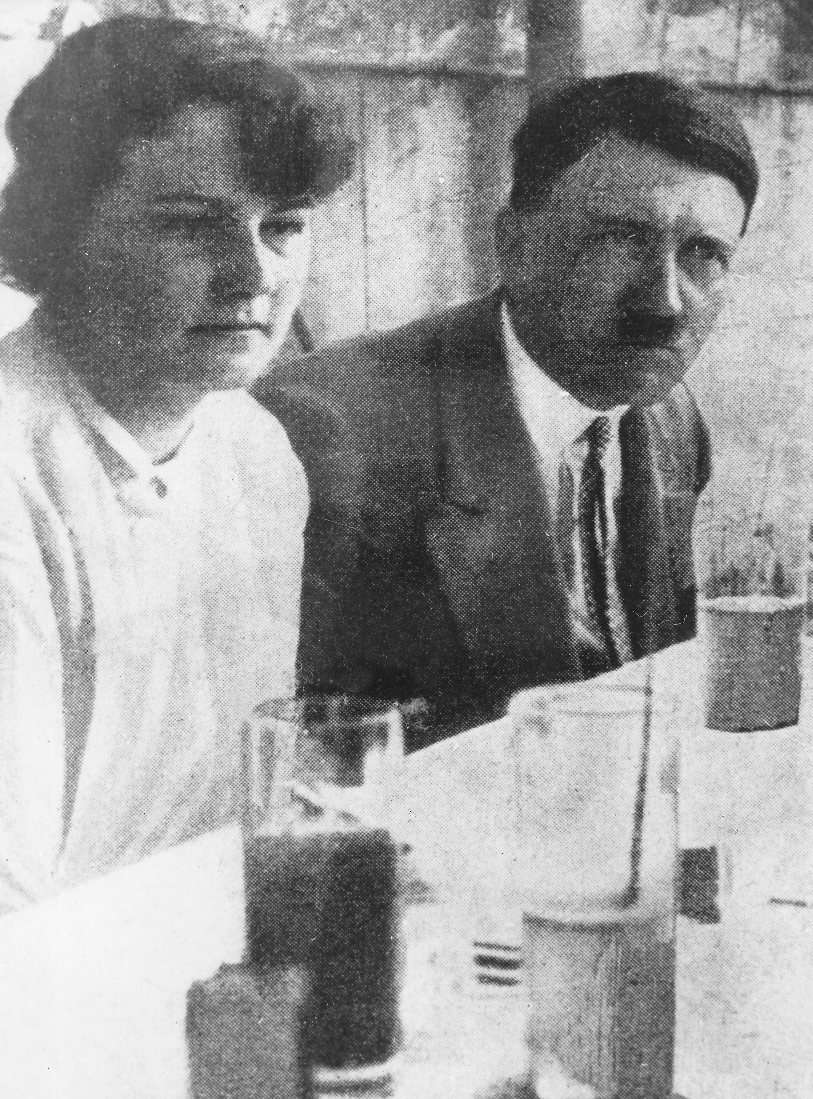 Ein Mann und eine Frau sitzen an einem Tisch mit Getränken, schwarz-weiß Fotografie.