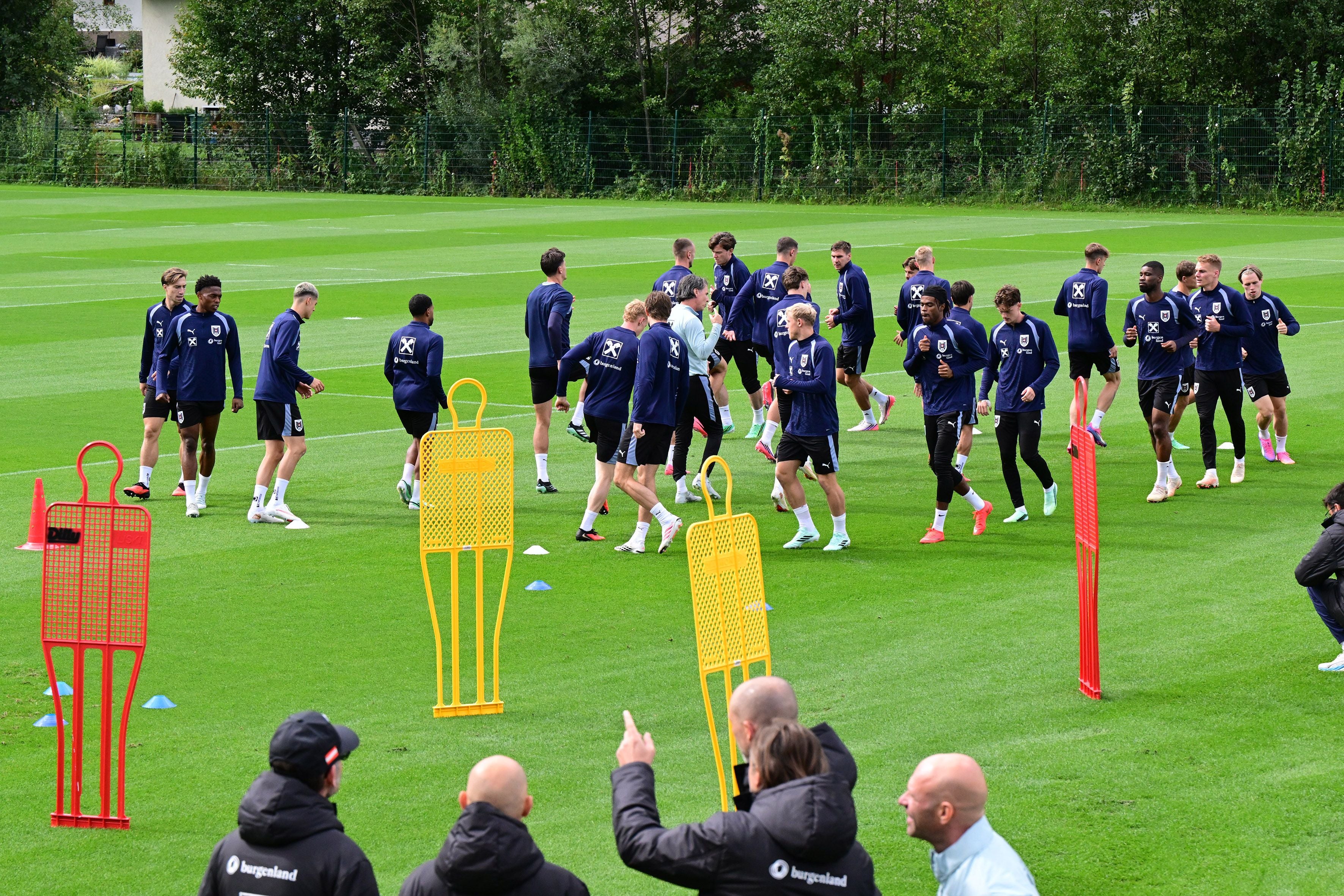 Das österreichische Fußballnationalteam trainiert auf einem grünen Spielfeld mit Dummys und Trainern.
