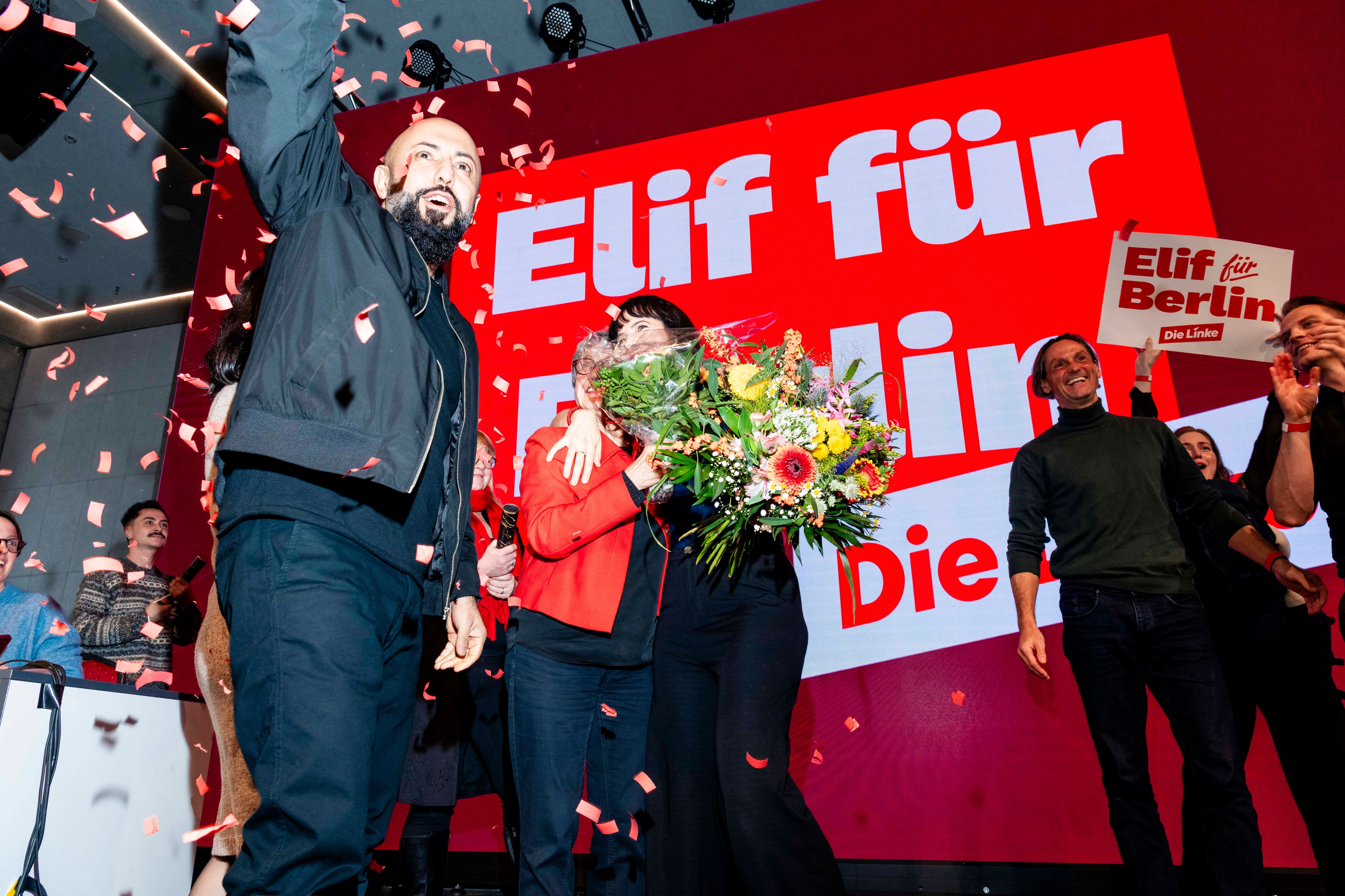 Elif Eralp feiert mit Blumenstrauß und Anhängern auf einer Bühne voller roter Konfetti.