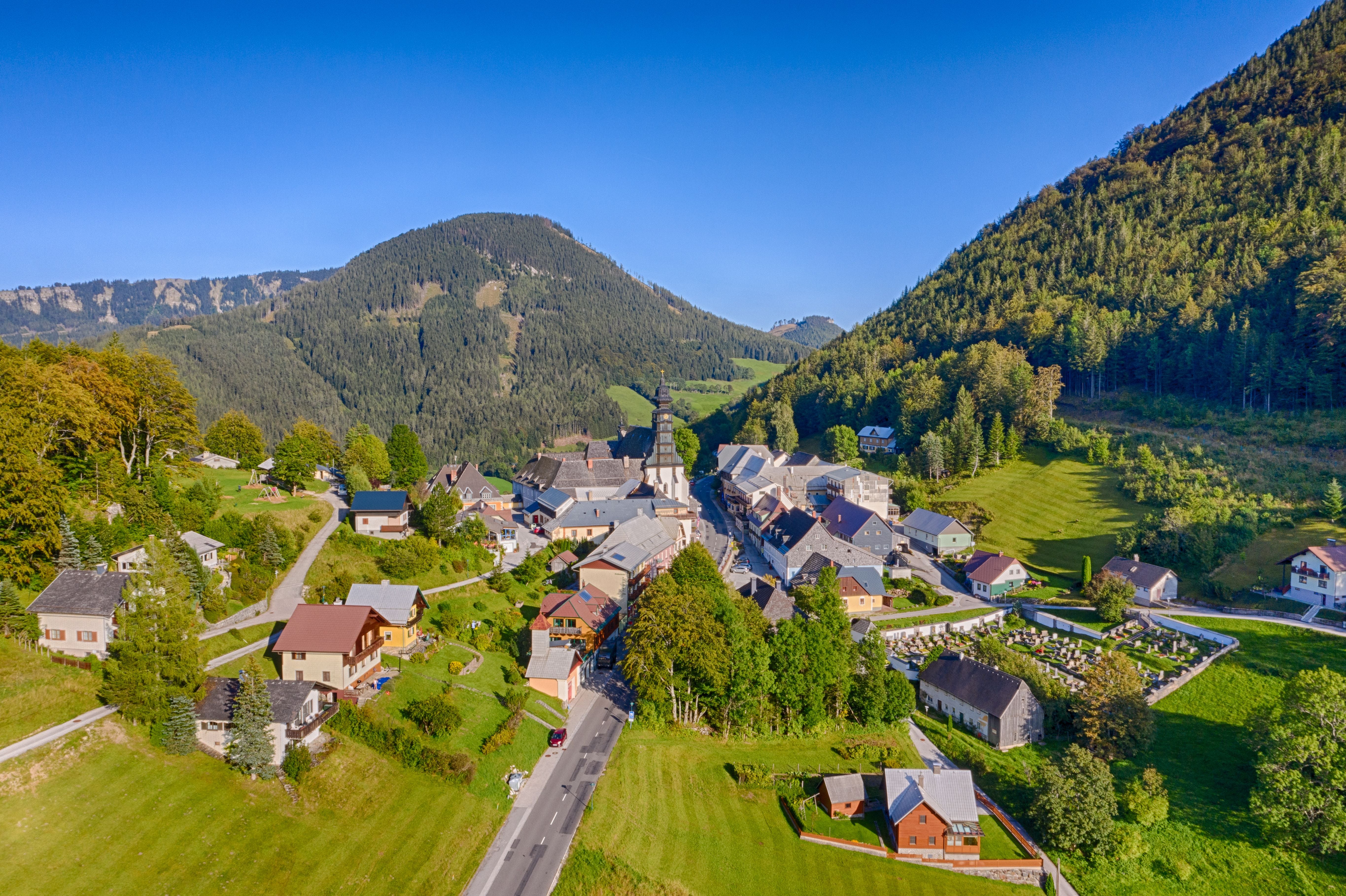 Luftaufnahme von Annaberg in Niederösterreich mit Häusern und umliegenden grünen Bergen.