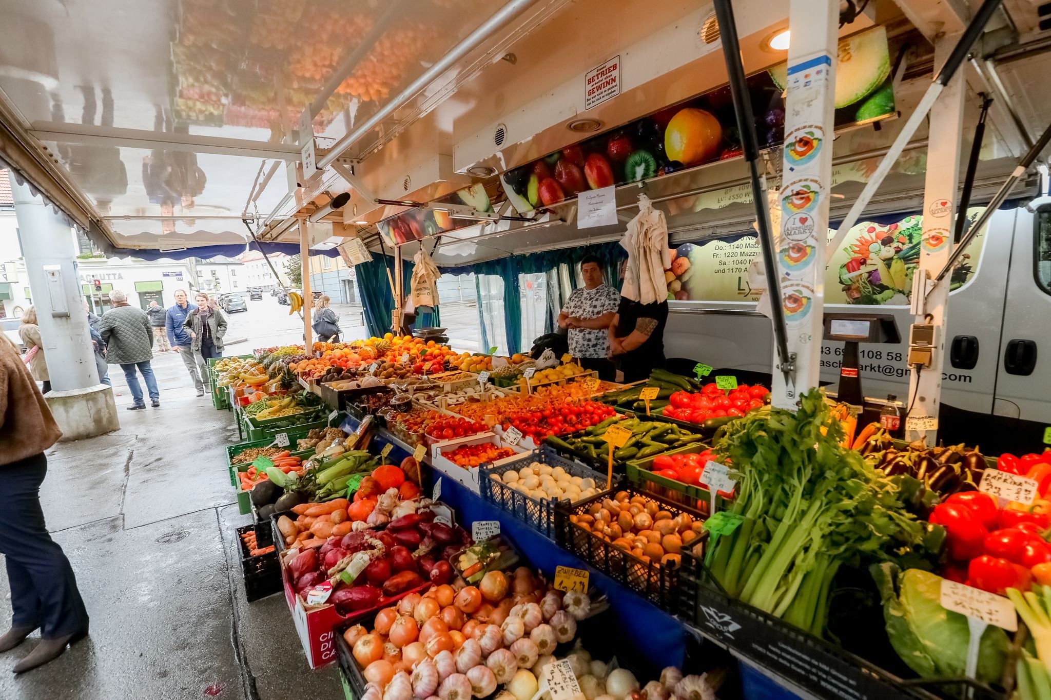 Gemüsestand auf einem Wochenmarkt mit verschiedenen frischen Obst- und Gemüsesorten.