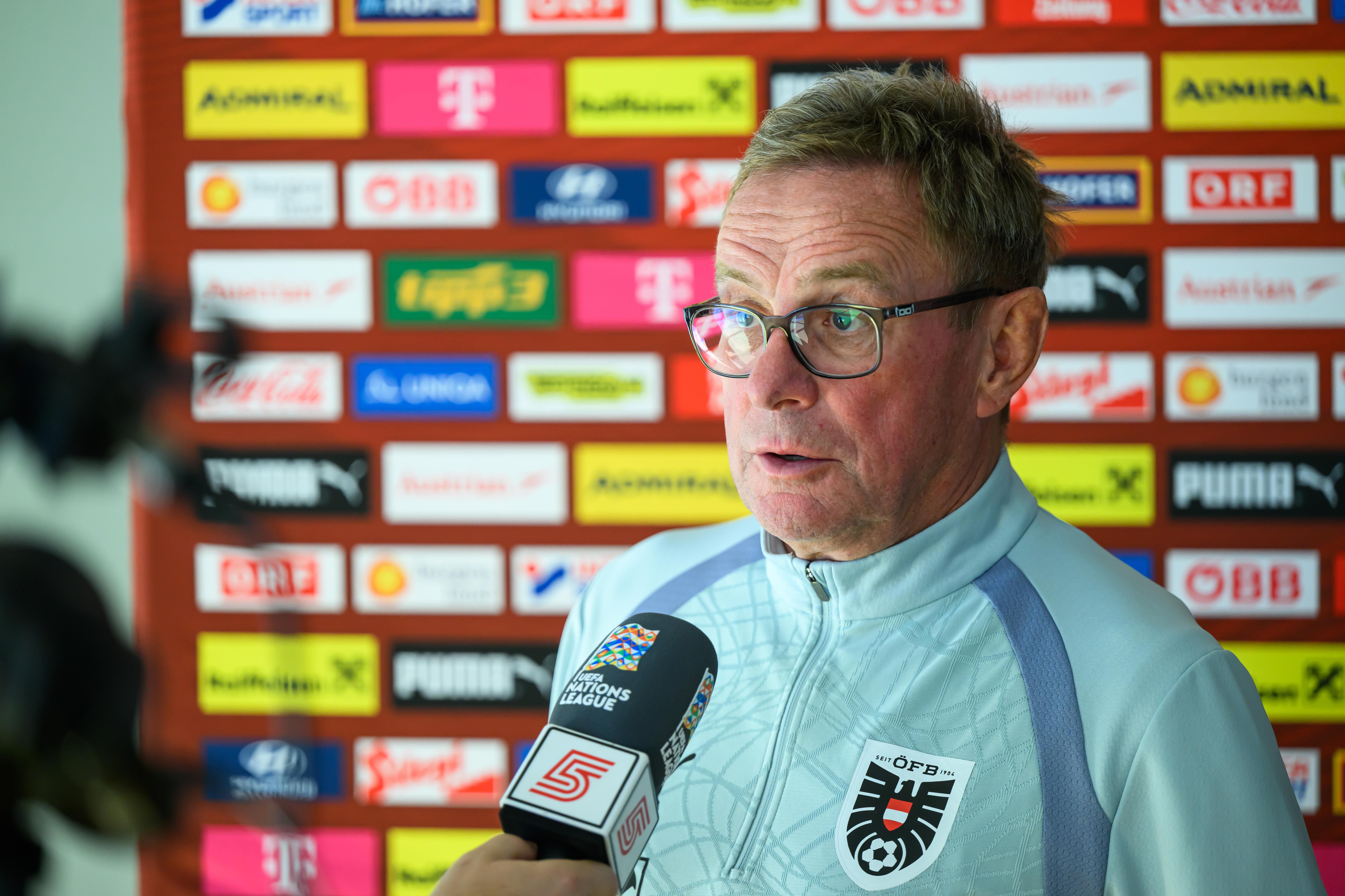 Ralf Rangnick gibt ein Interview bei einer Pressekonferenz vor Sponsorenwänden.