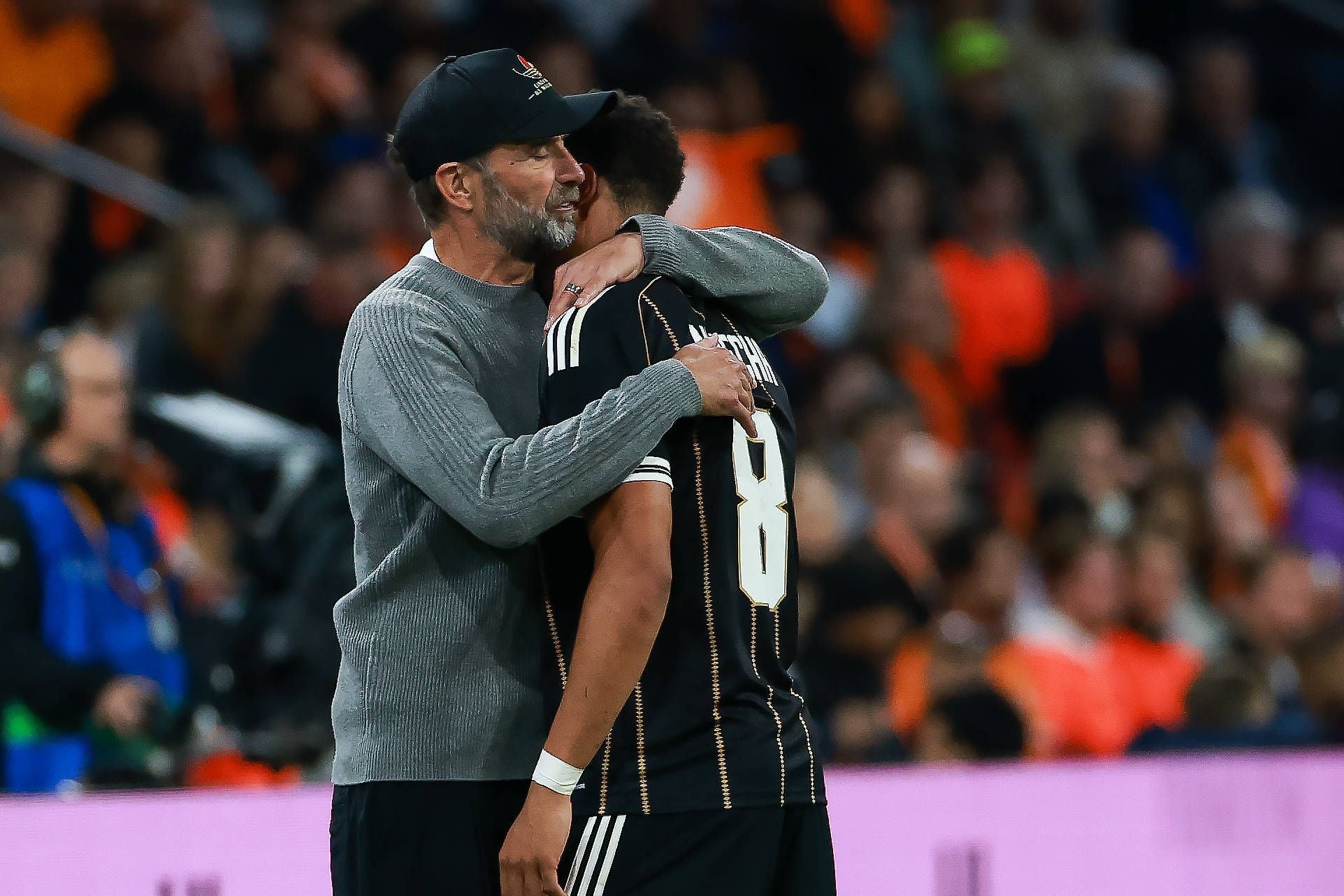 Jürgen Klopp umarmt Torschütze Felix Nmecha auf dem Spielfeld innig von der Seite.