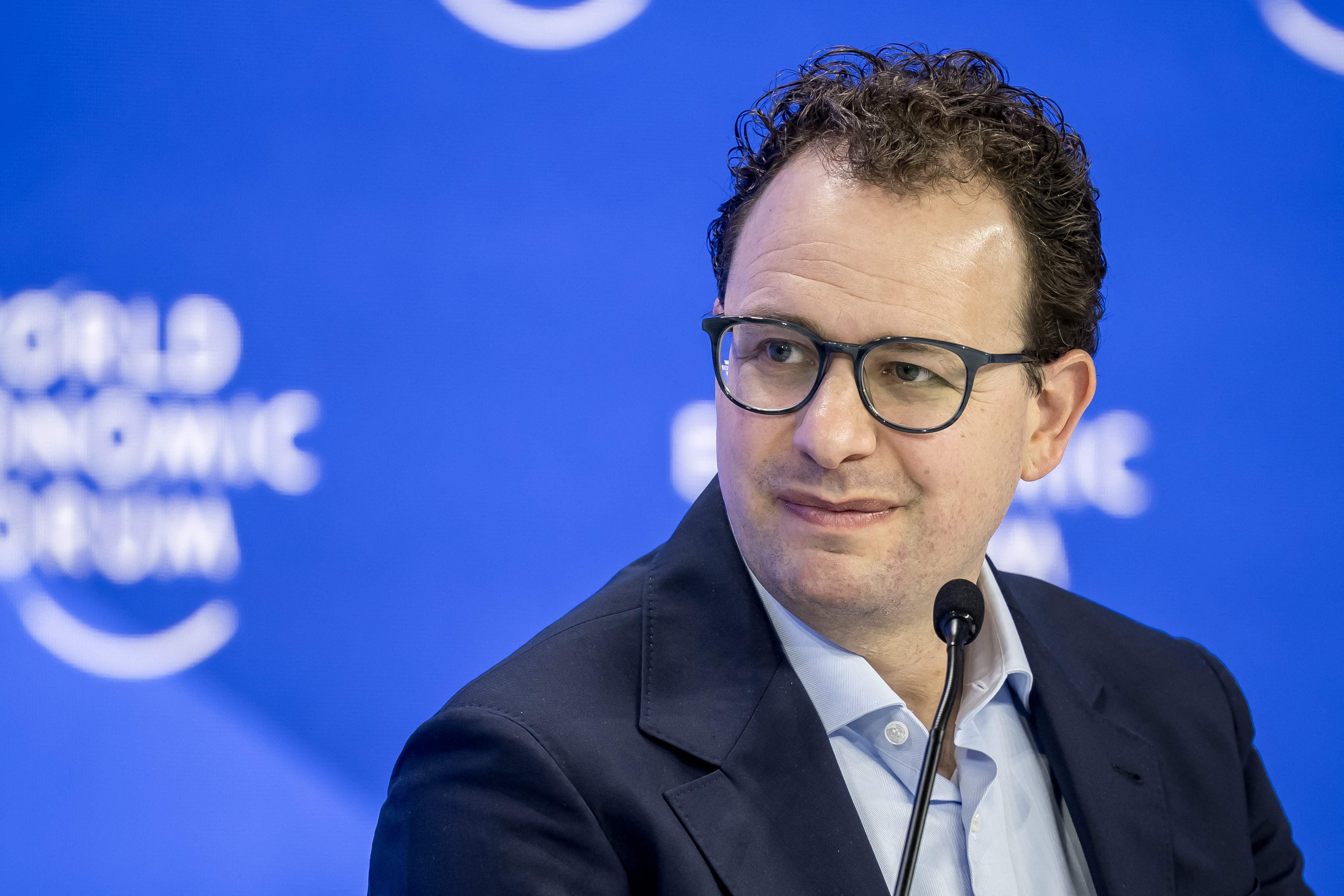Ein Mann mit Brille spricht auf einer Bühne vor blauem Hintergrund mit „World Economic Forum“-Logo.