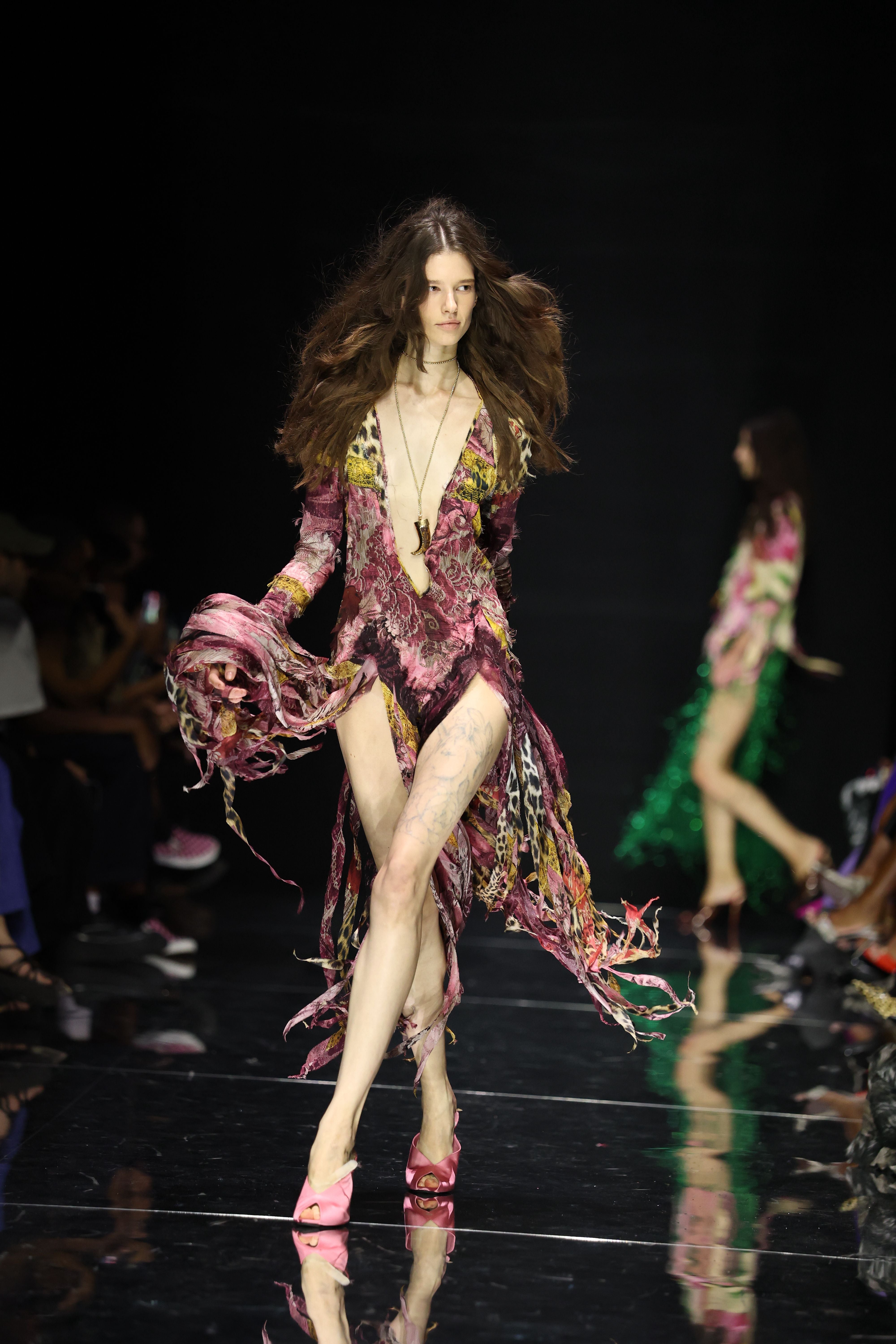 Model trägt ein bunt gemustertes, asymmetrisches Kleid auf dem Laufsteg der Milan Fashion Week.
