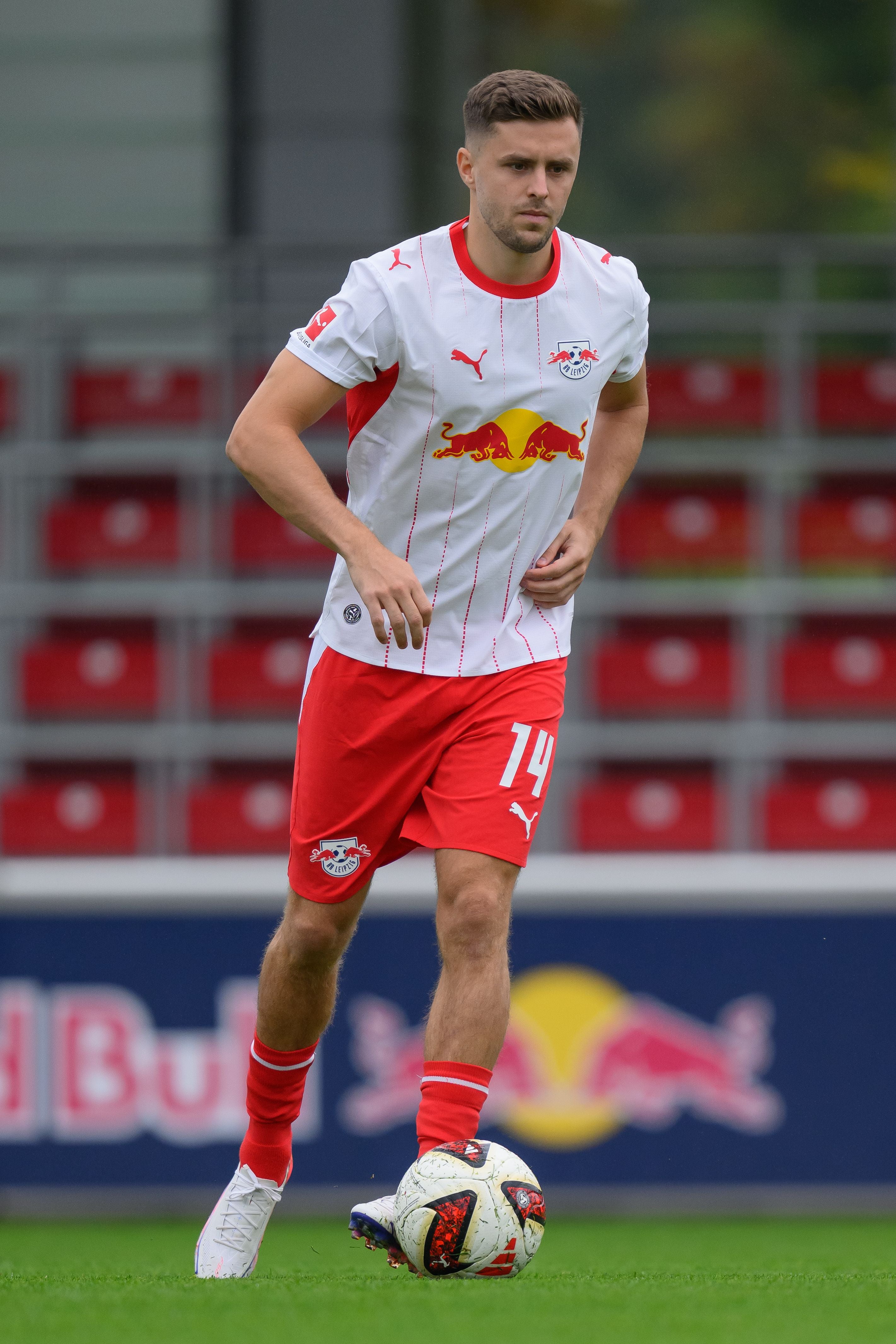 Ein Fußballspieler von RB Leipzig läuft auf dem Spielfeld mit einem Ball am Fuß.
