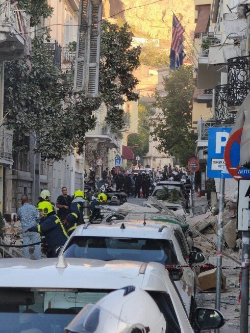 Feuerwehrleute und Polizei sichern eine Straße in Athen nach einem Gebäudeeinsturz.