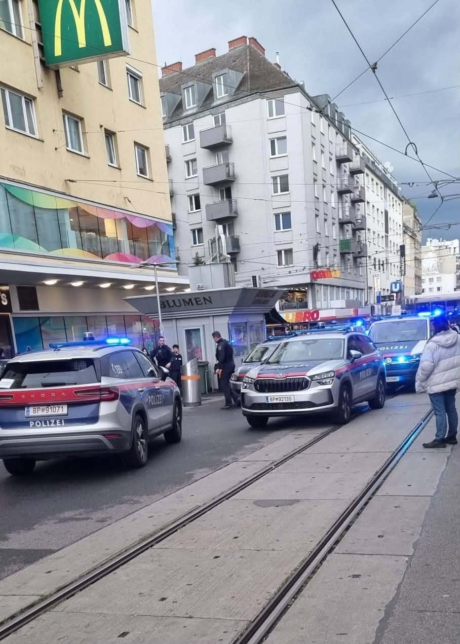 Mehrere Polizeiautos mit Blaulicht vor einem Gebäude im Wiener Bezirk Favoriten.